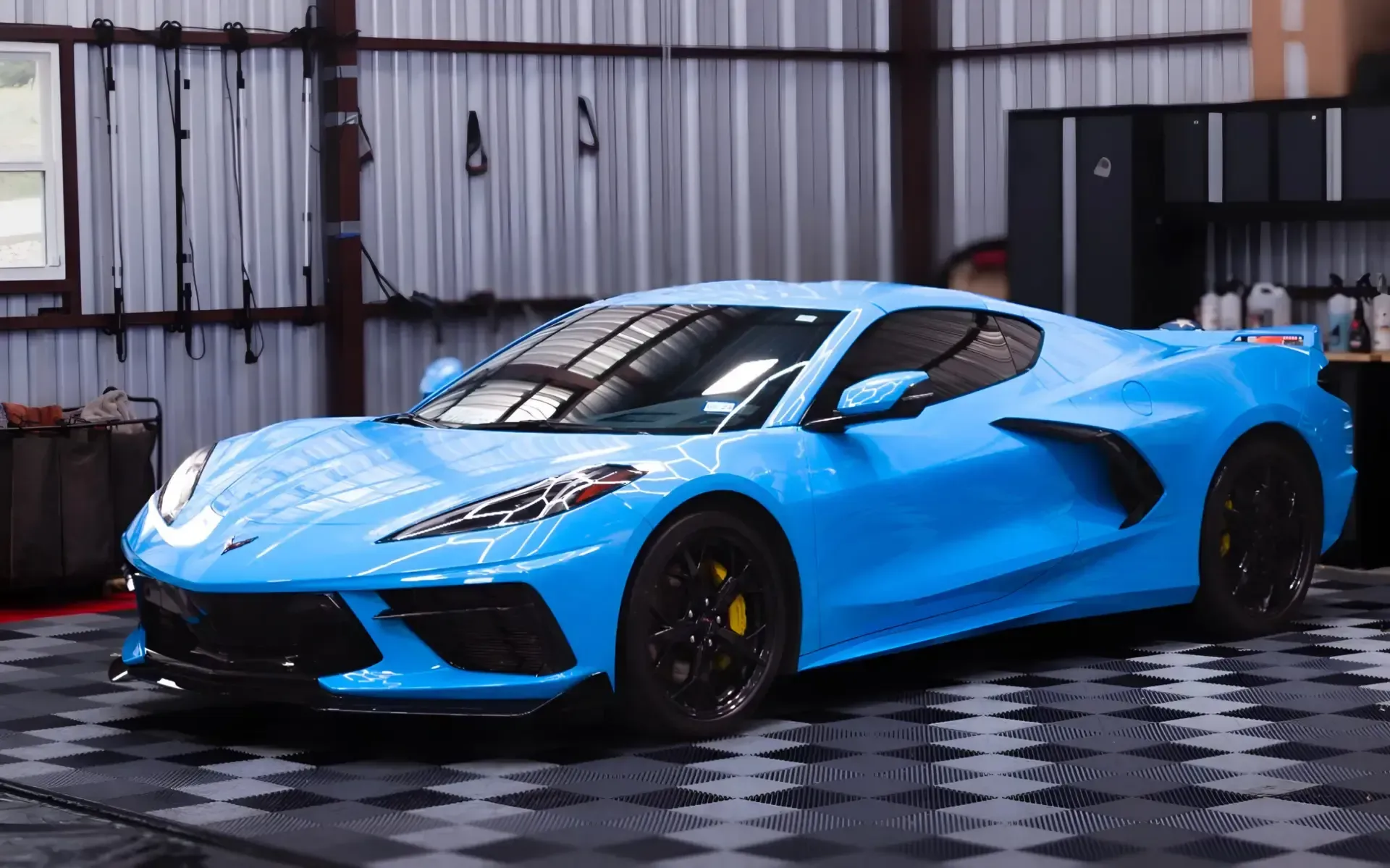 A blue sports car is parked in a garage.