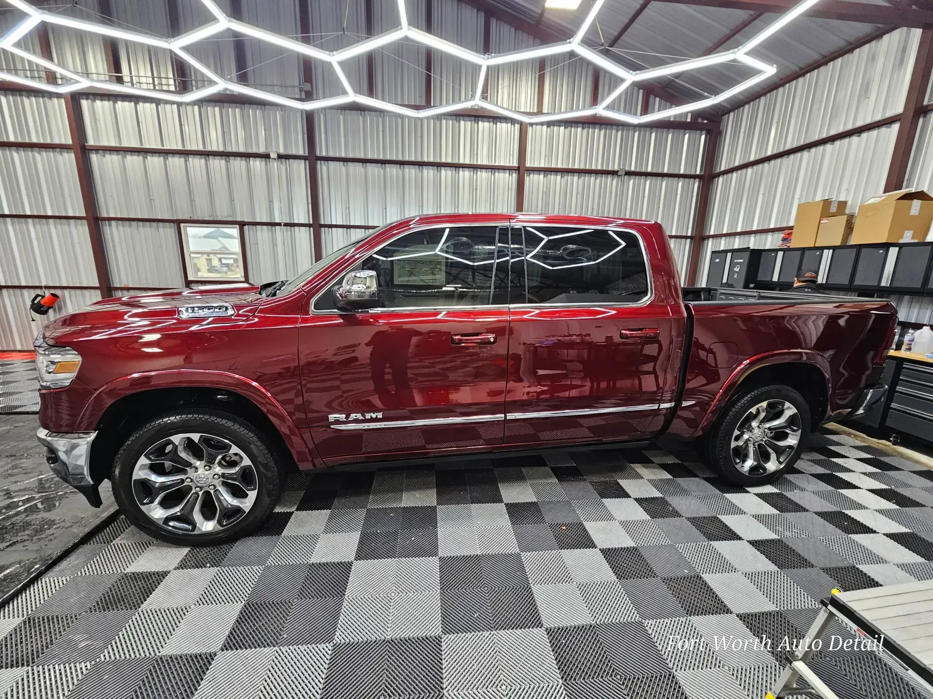 A red ram truck is parked in a garage with a checkered floor.