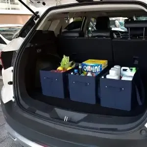 The trunk of a car is filled with boxes and bottles.