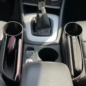 A car with a cup holder and a wallet in it.