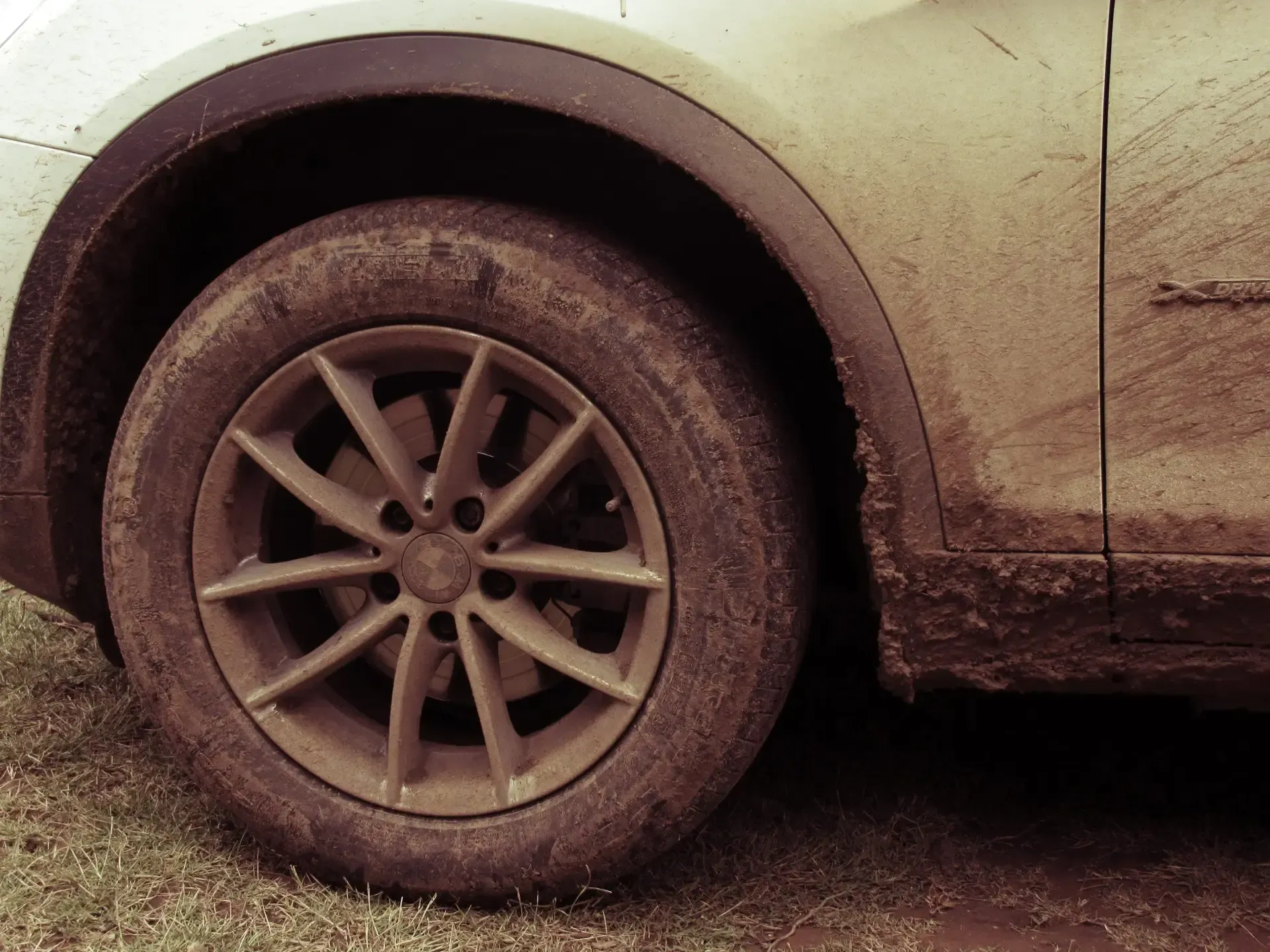 A close up of a muddy tire on a car