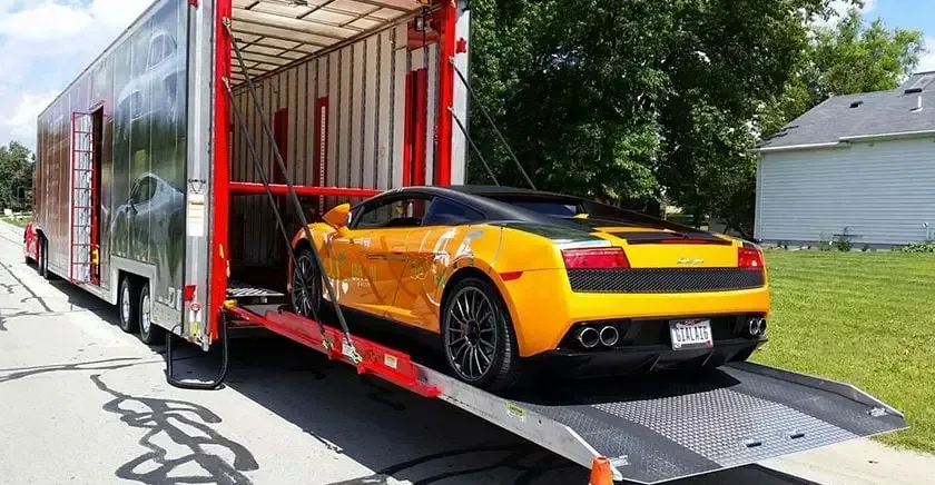 A yellow sports car is being transported on a trailer.