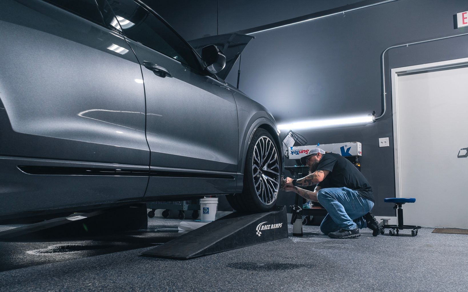 A man is working on a car in a garage.