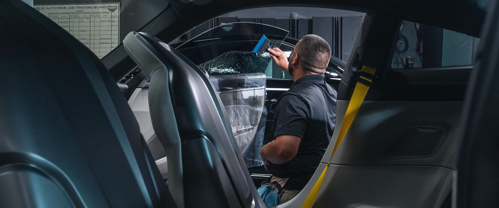 A man is sitting in the driver 's seat of a car.