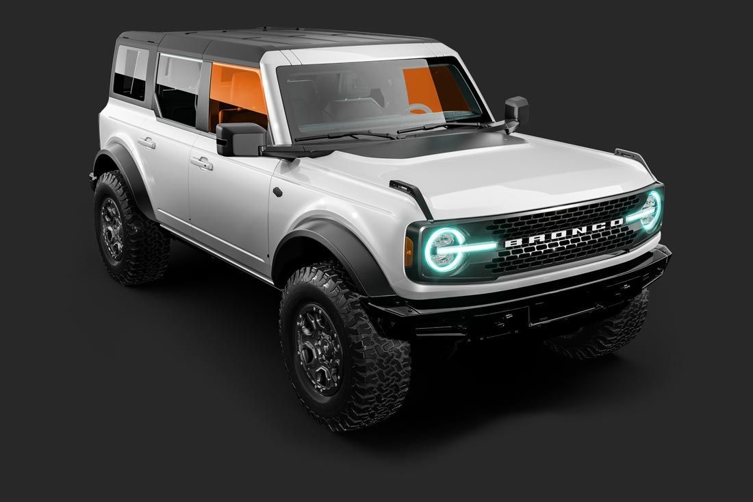 A white ford bronco with green lights on the front is on a black background.