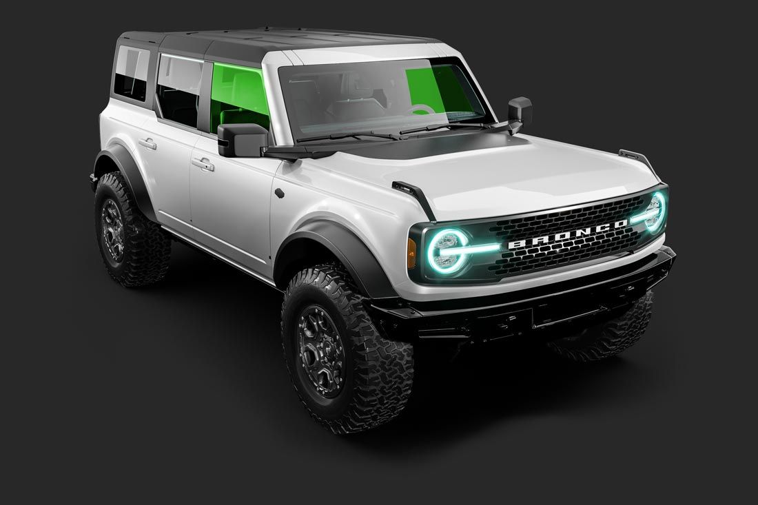 A white ford bronco with green lights on the front is on a black background.
