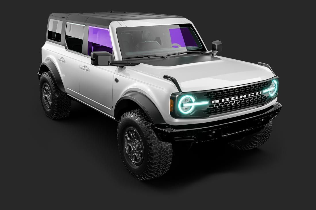 A white ford bronco with purple lights on the front is on a black background.