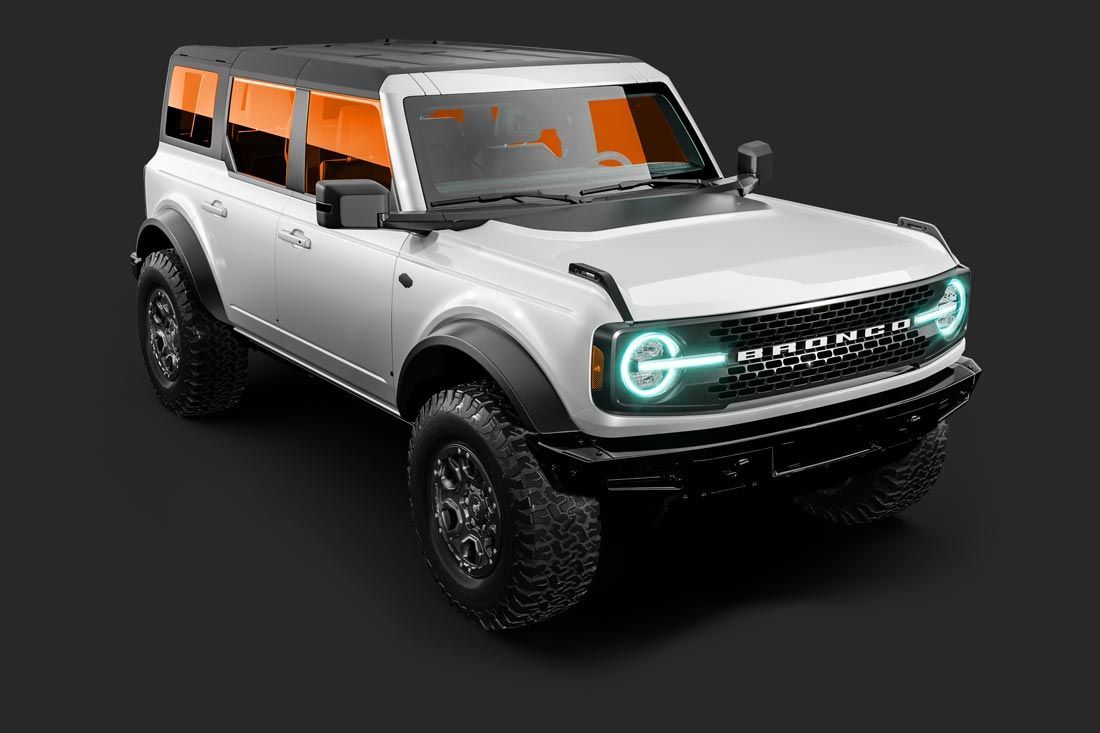 A white ford bronco with green lights on the front is on a black background.