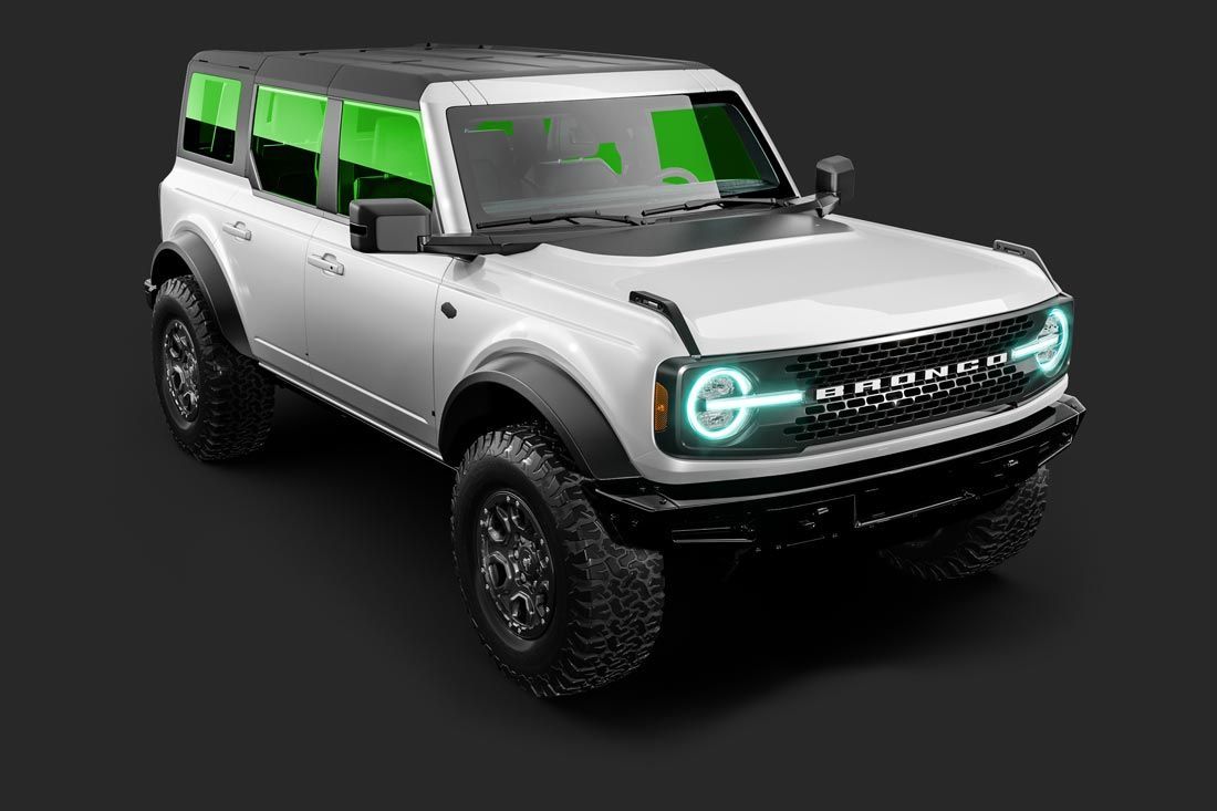 A white ford bronco with green lights on the front is on a black background.