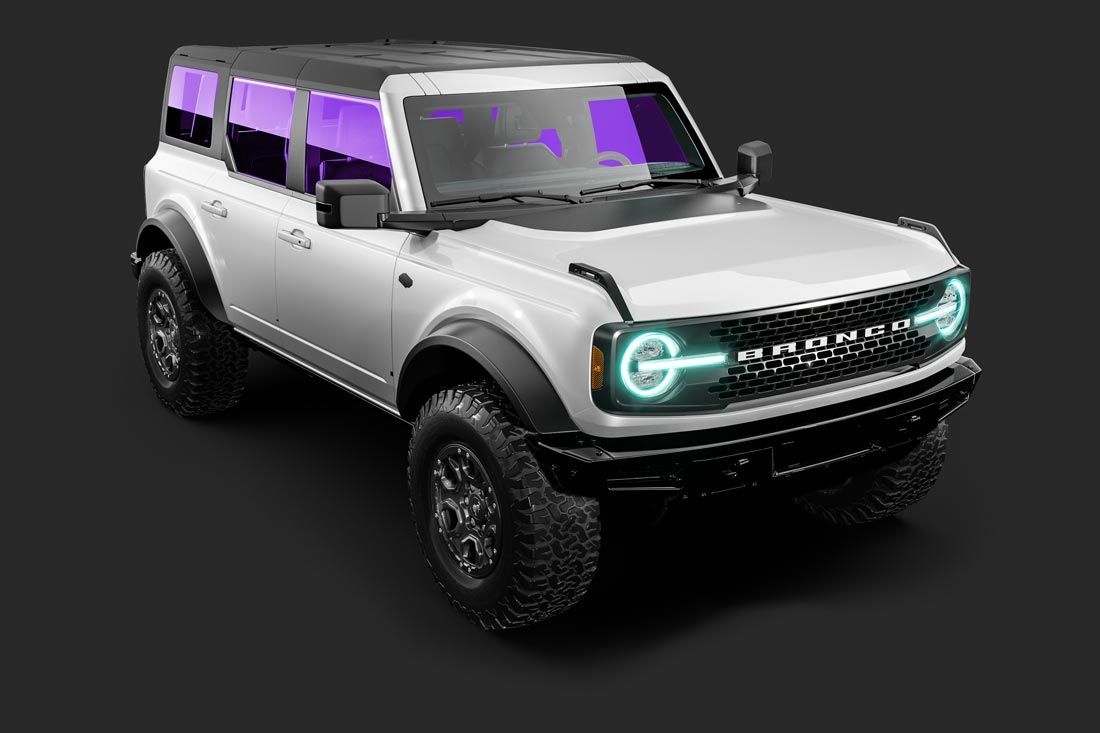 A white ford bronco with purple lights on the front is on a black background.