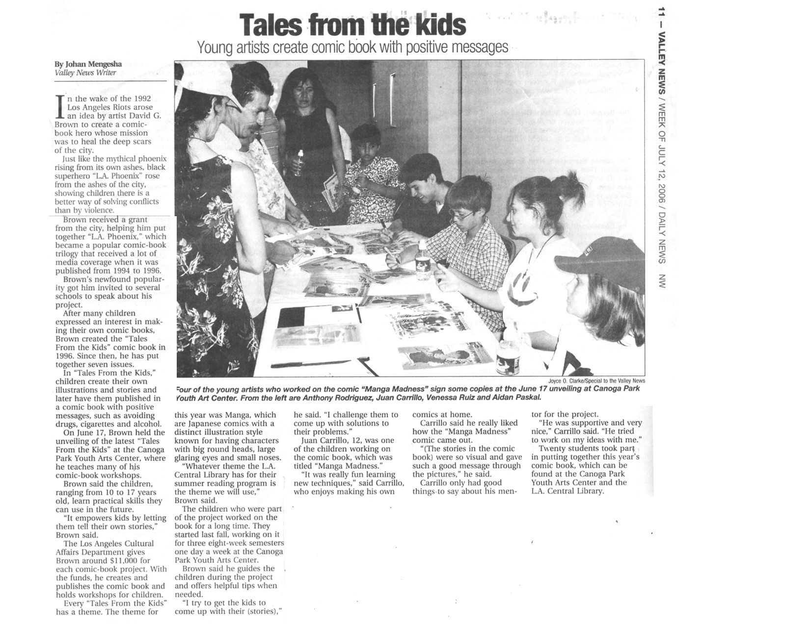 Children and adults gathered around a table; a newspaper article about kids' tales.