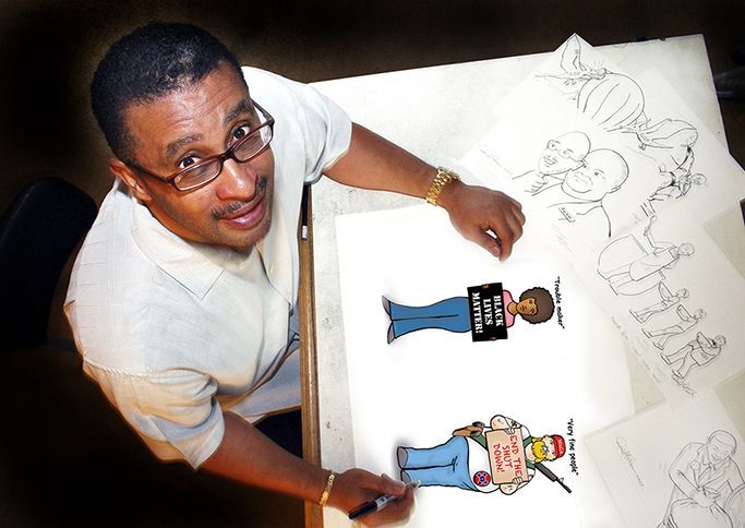 Man at desk drawing cartoons. Holding marker, looking up. Color drawings of people on paper.