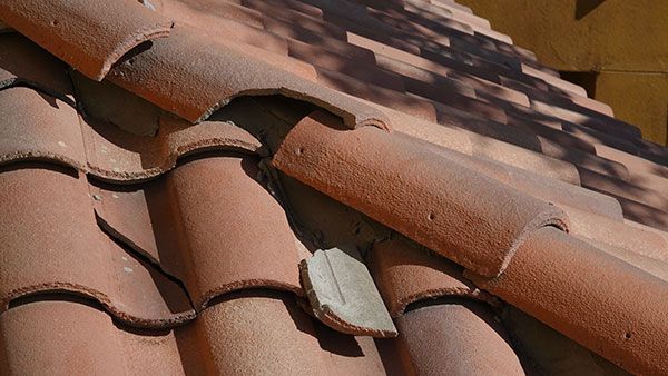 Broken Red terracotta roof tiles, close-up view in daylight.