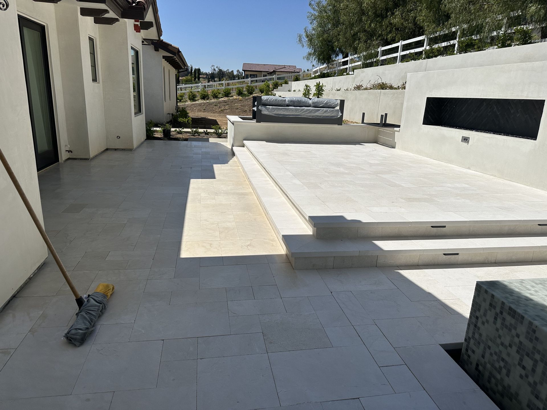 A mop is sitting on a patio in front of a house