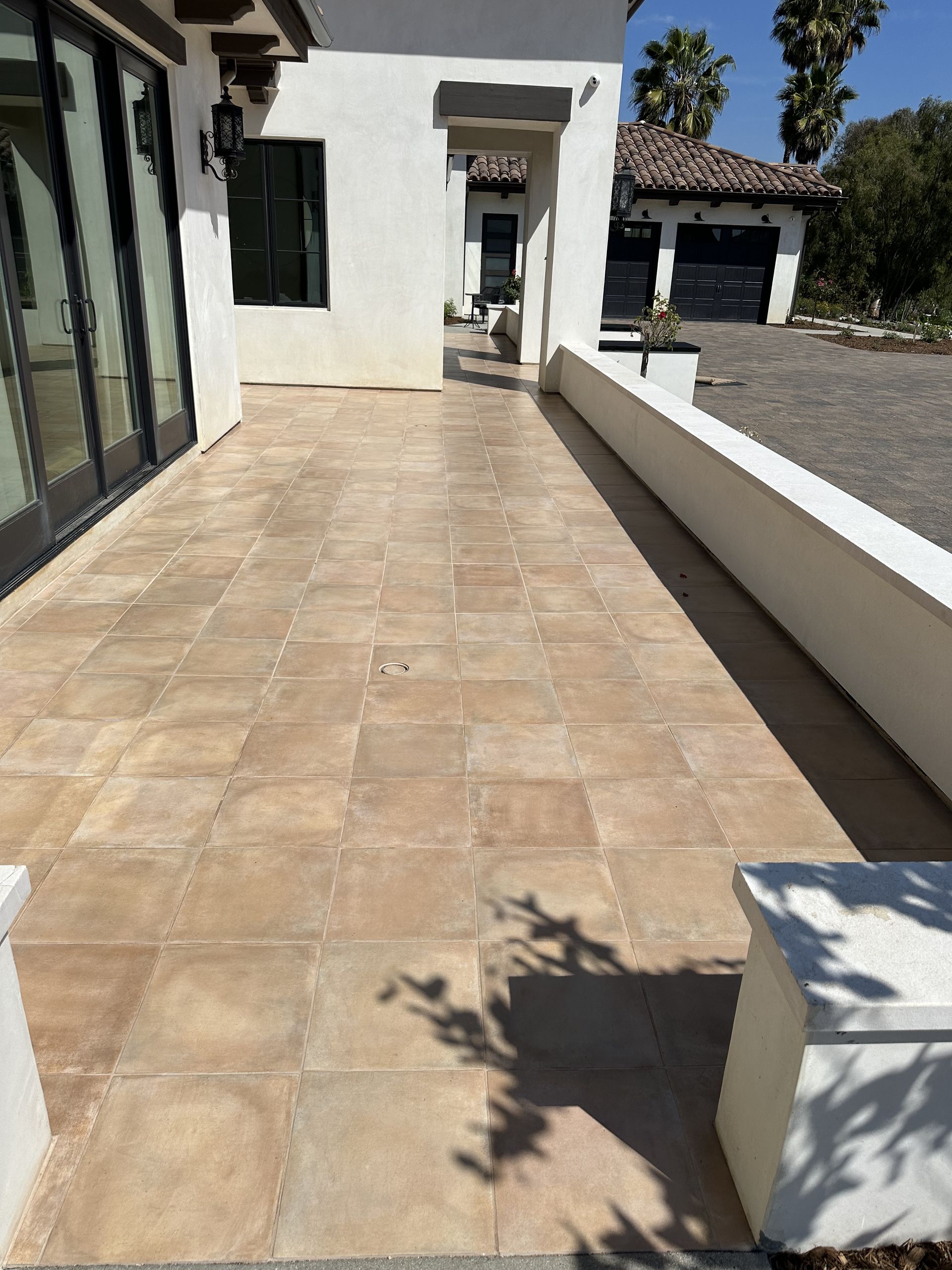 A tiled walkway leading to a white house