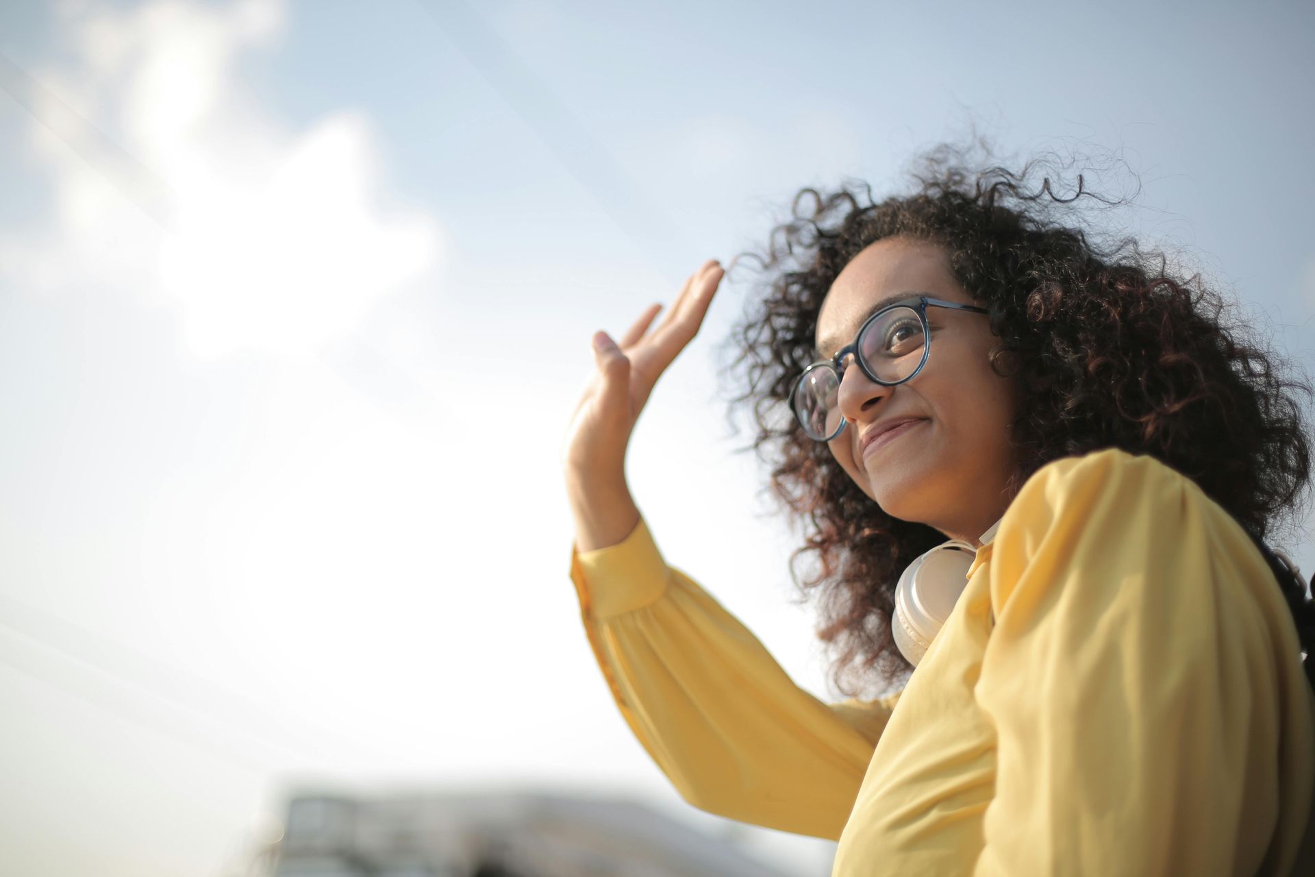 Woman in yellow waving