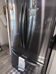 A dark stainless steel French door refrigerator with a 