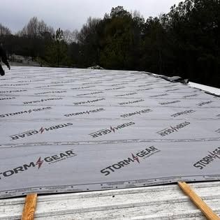 A man is standing on top of a roof with a piece of paper on it.