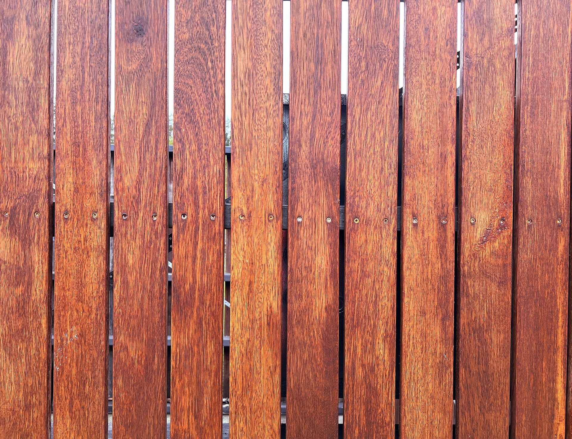 A close up of a wooden fence with a few holes in it
