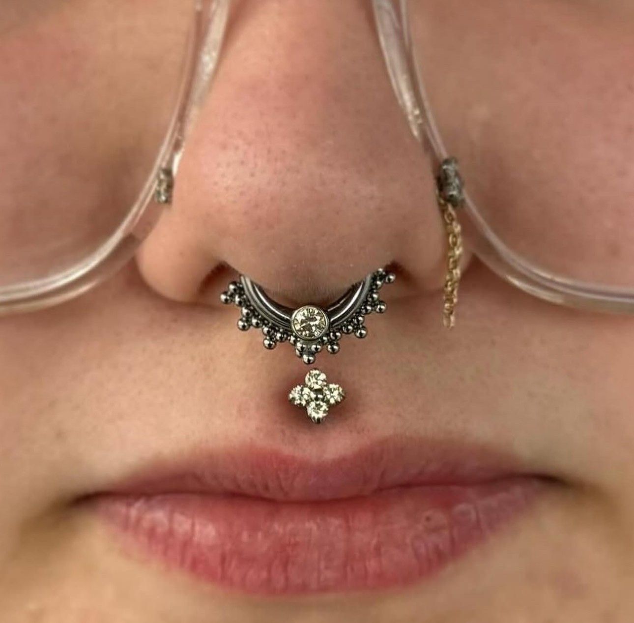 A close up of a woman 's nose with a nose ring and glasses. - Manhattan, NY - Studio 28 Tattoo