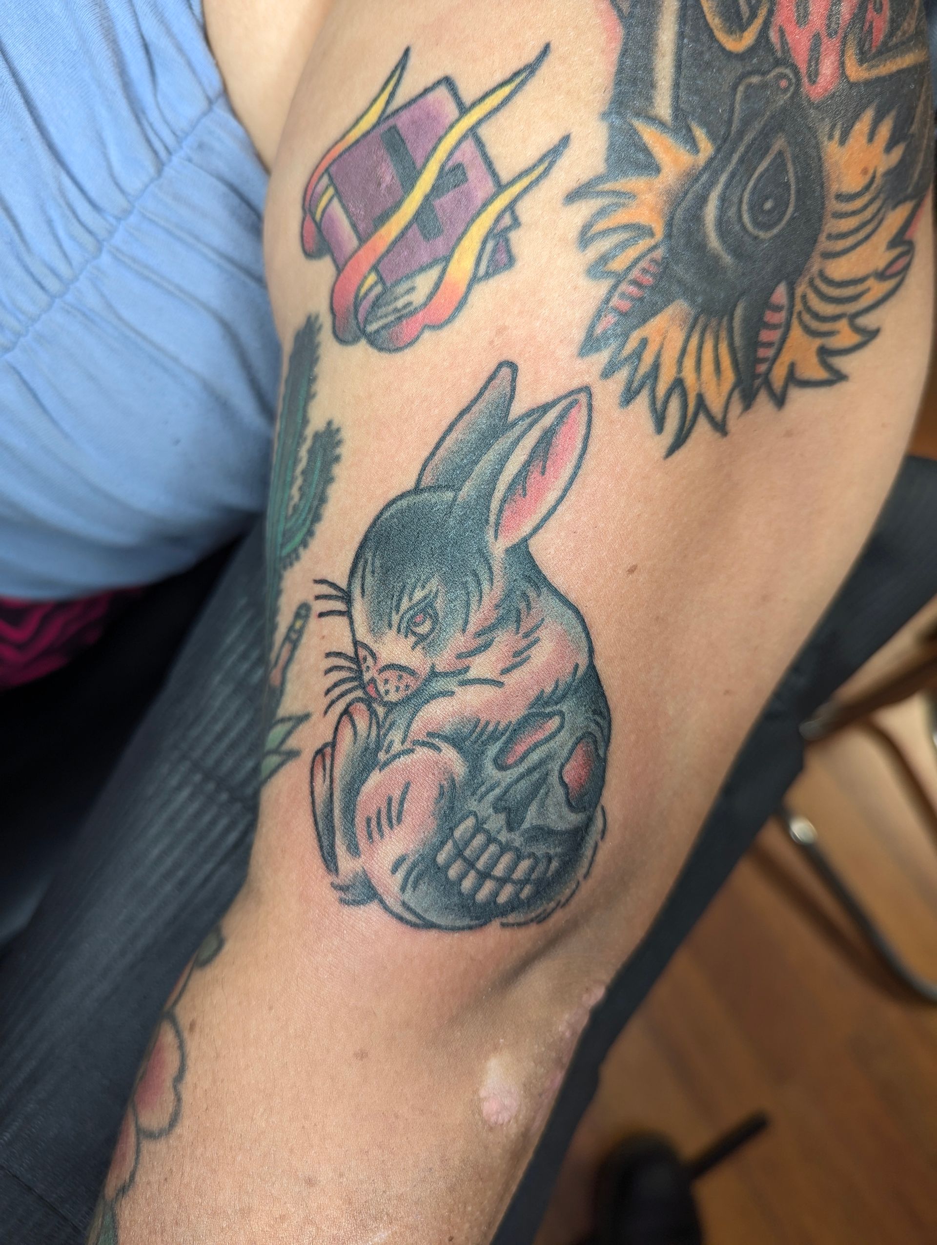 A person has a tattoo of a rabbit on their arm