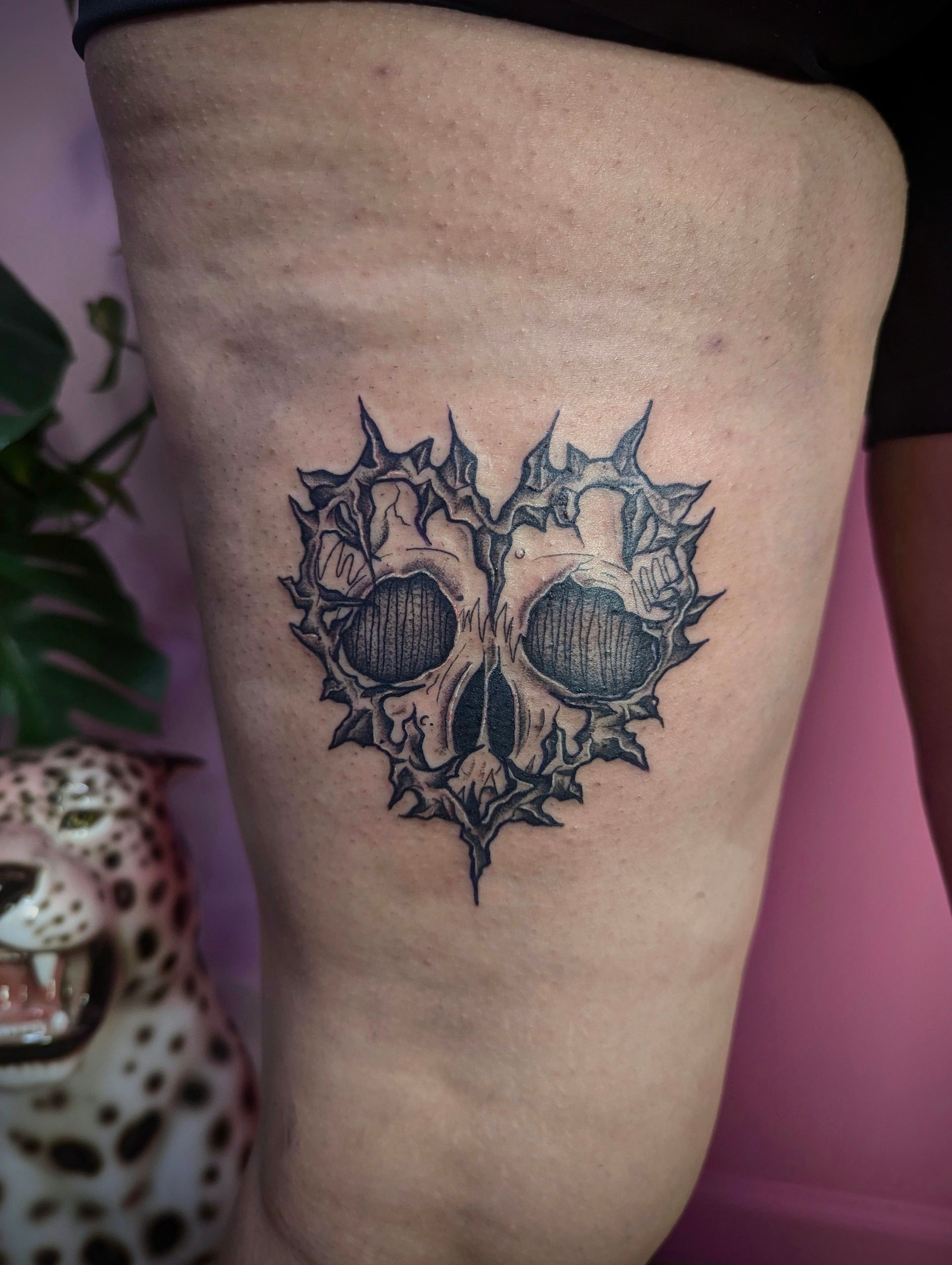 A tattoo of a skull in the shape of a heart