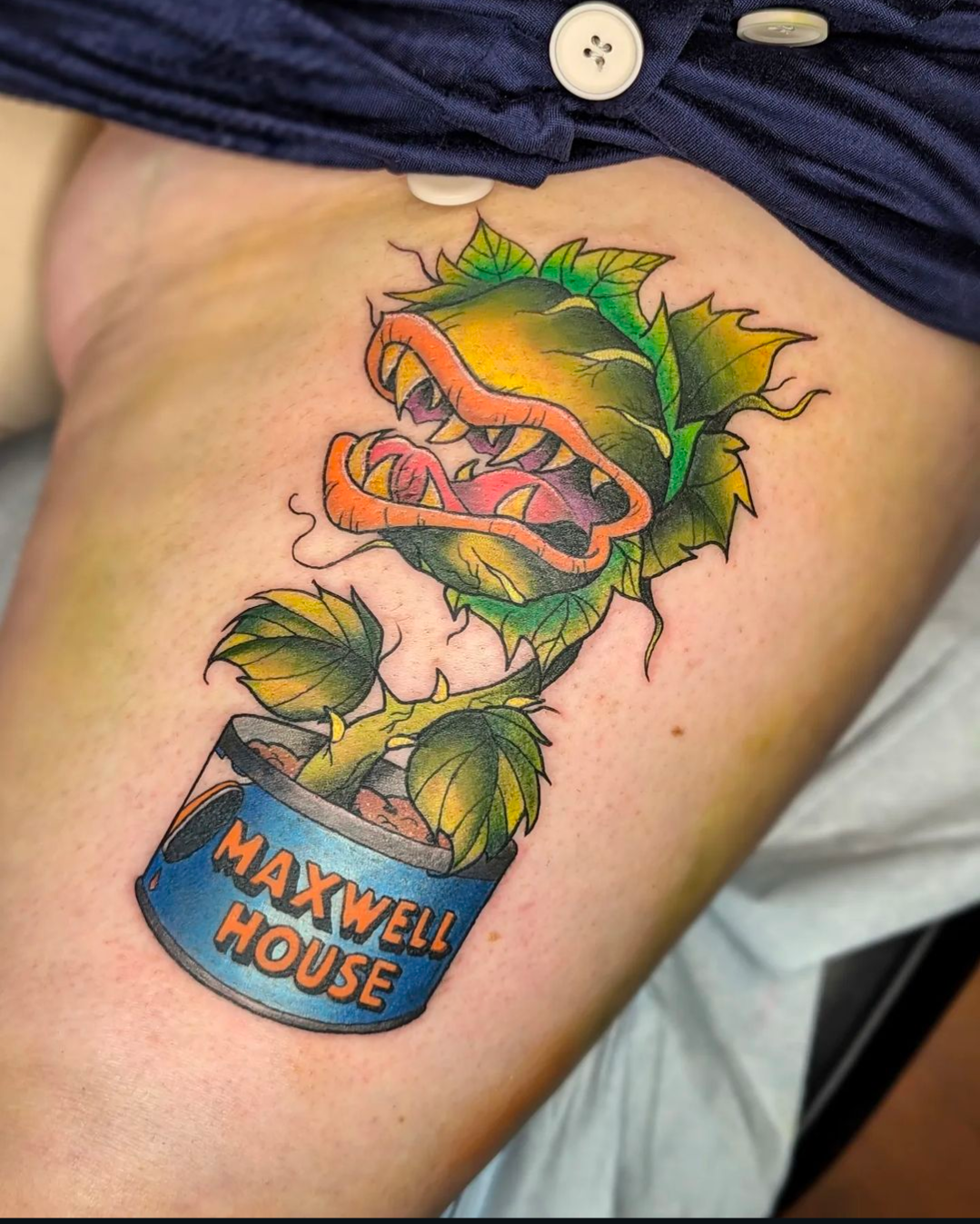 A tattoo of a carnivorous plant in a can that says maxwell house