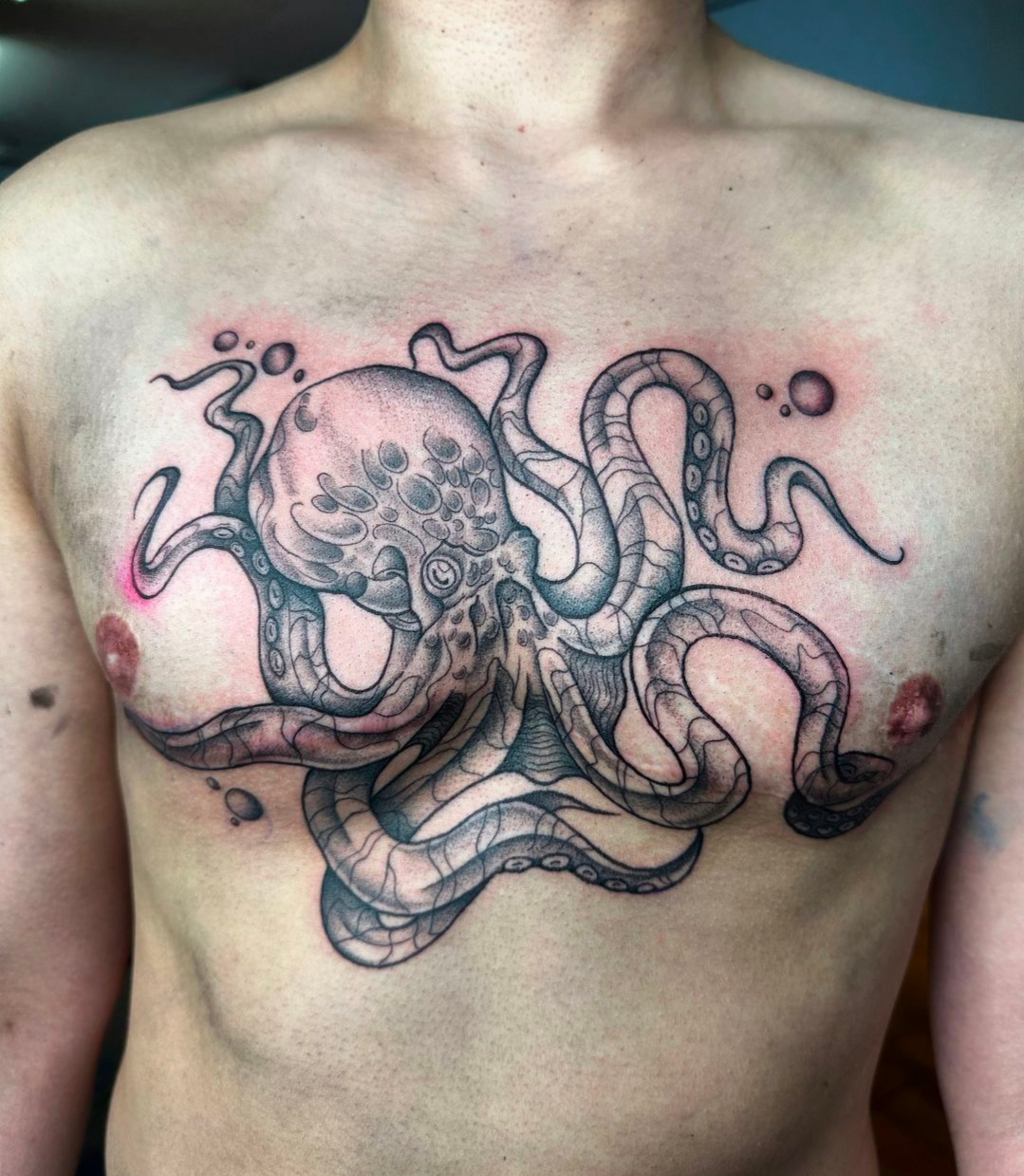 A man has an octopus tattoo on his chest