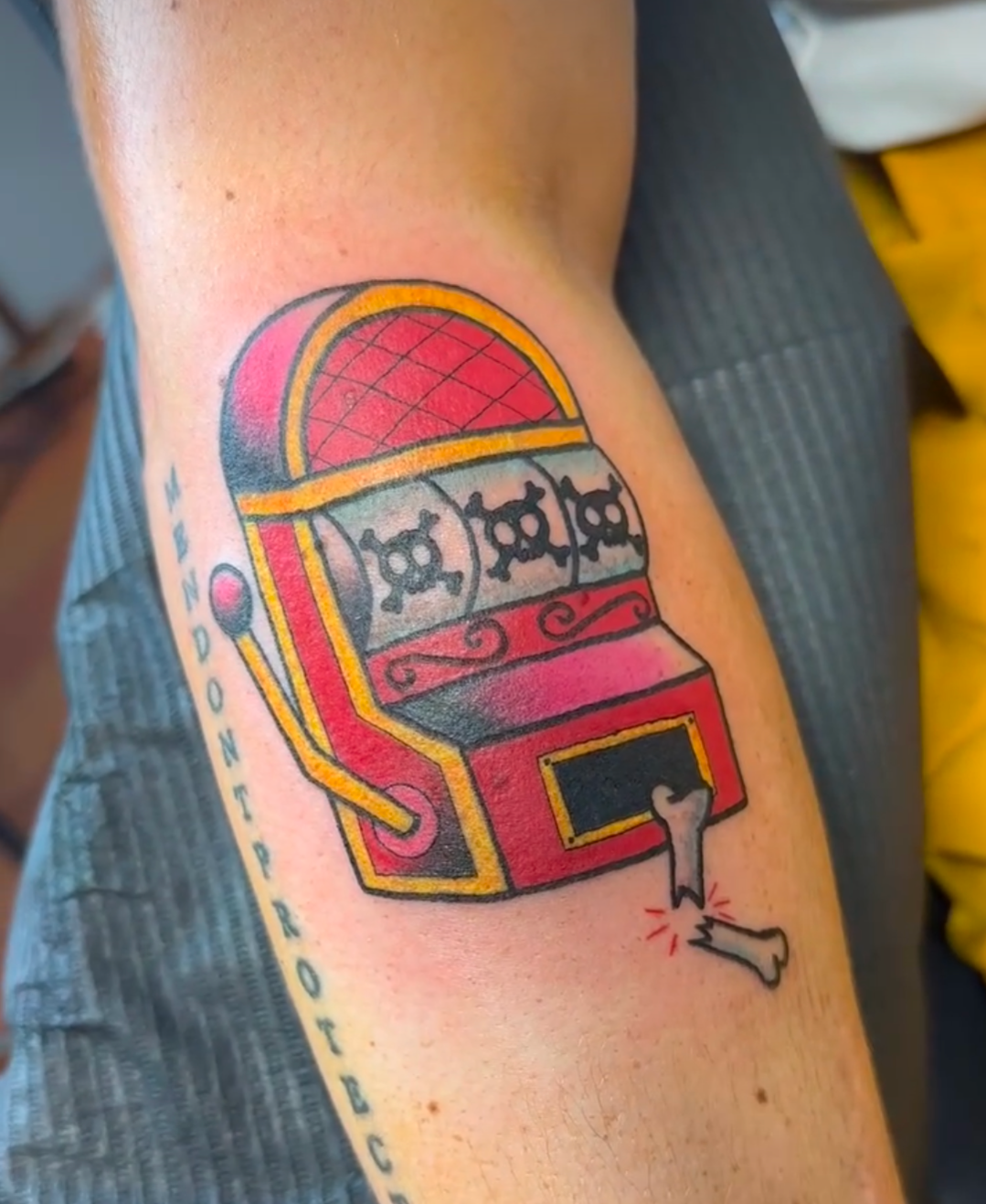 A man has a tattoo of a slot machine on his arm