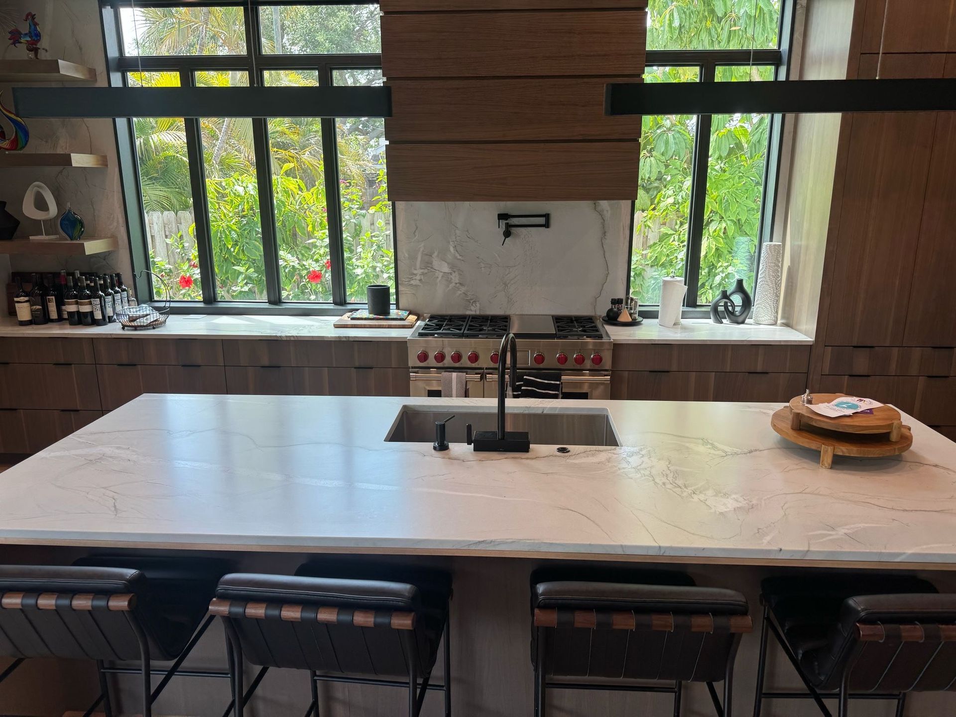A kitchen with blue cabinets , granite counter tops , stainless steel appliances and a sink.