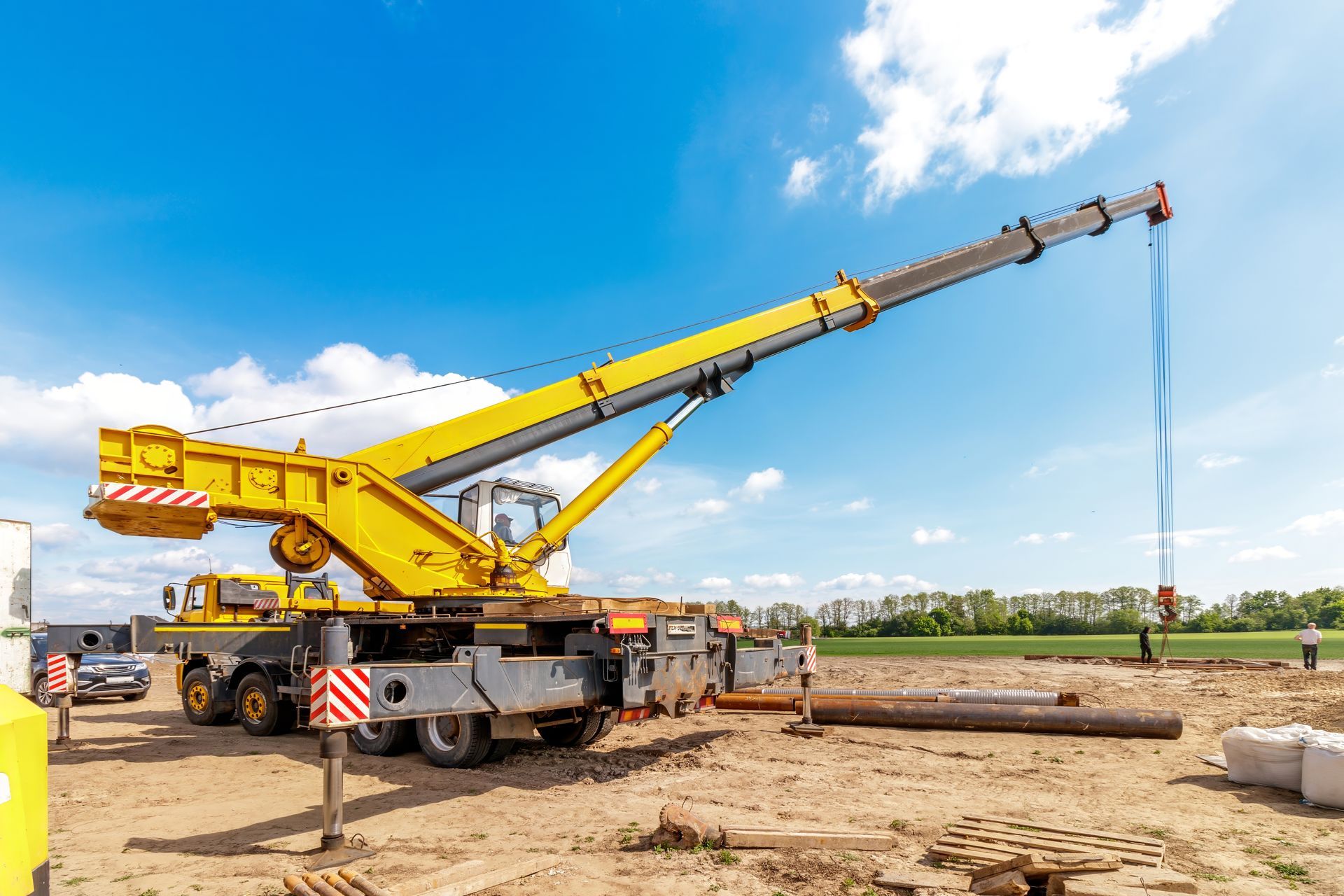 Crane service truck lifting materials at a construction site