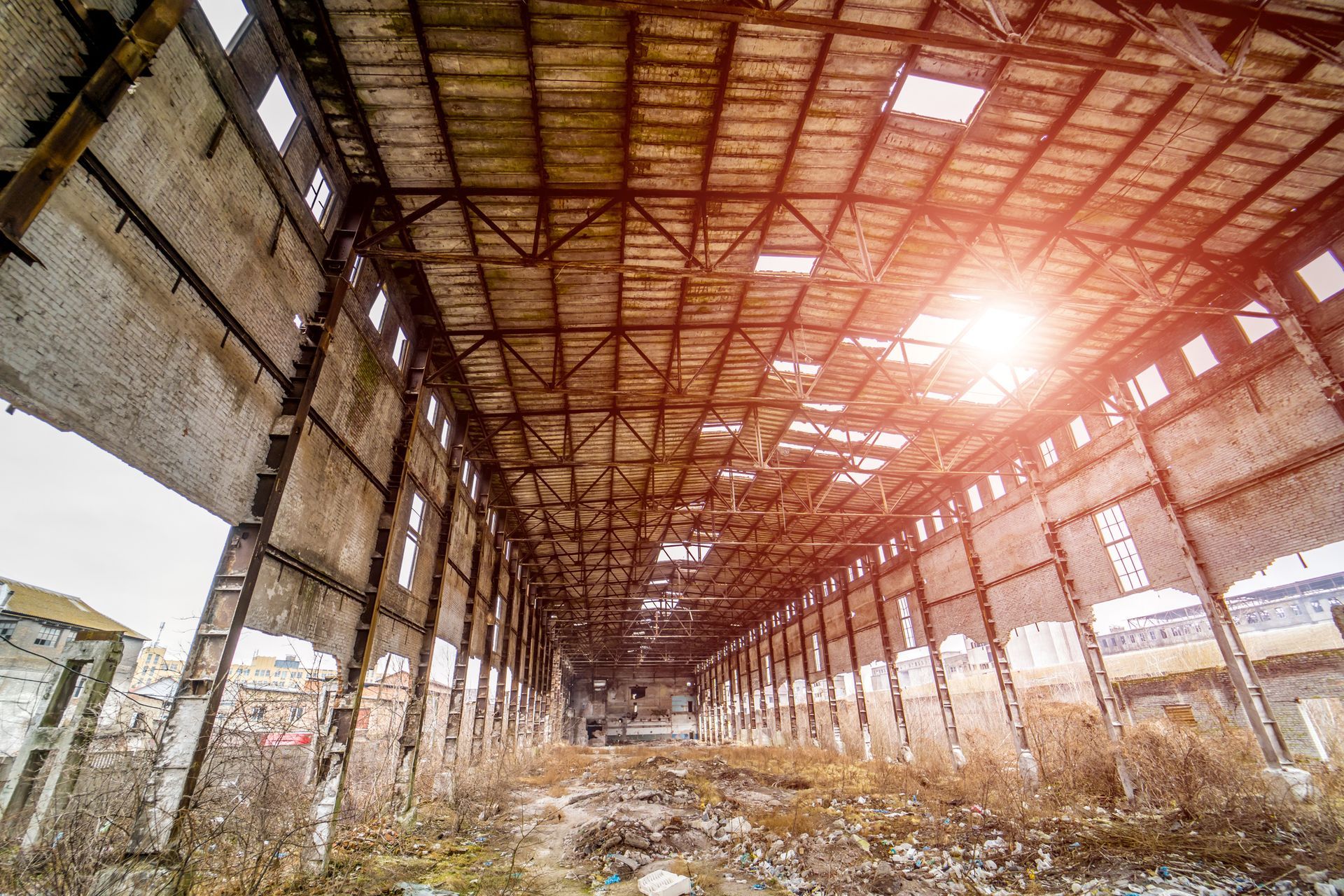 The sun is shining through the roof of an abandoned building.