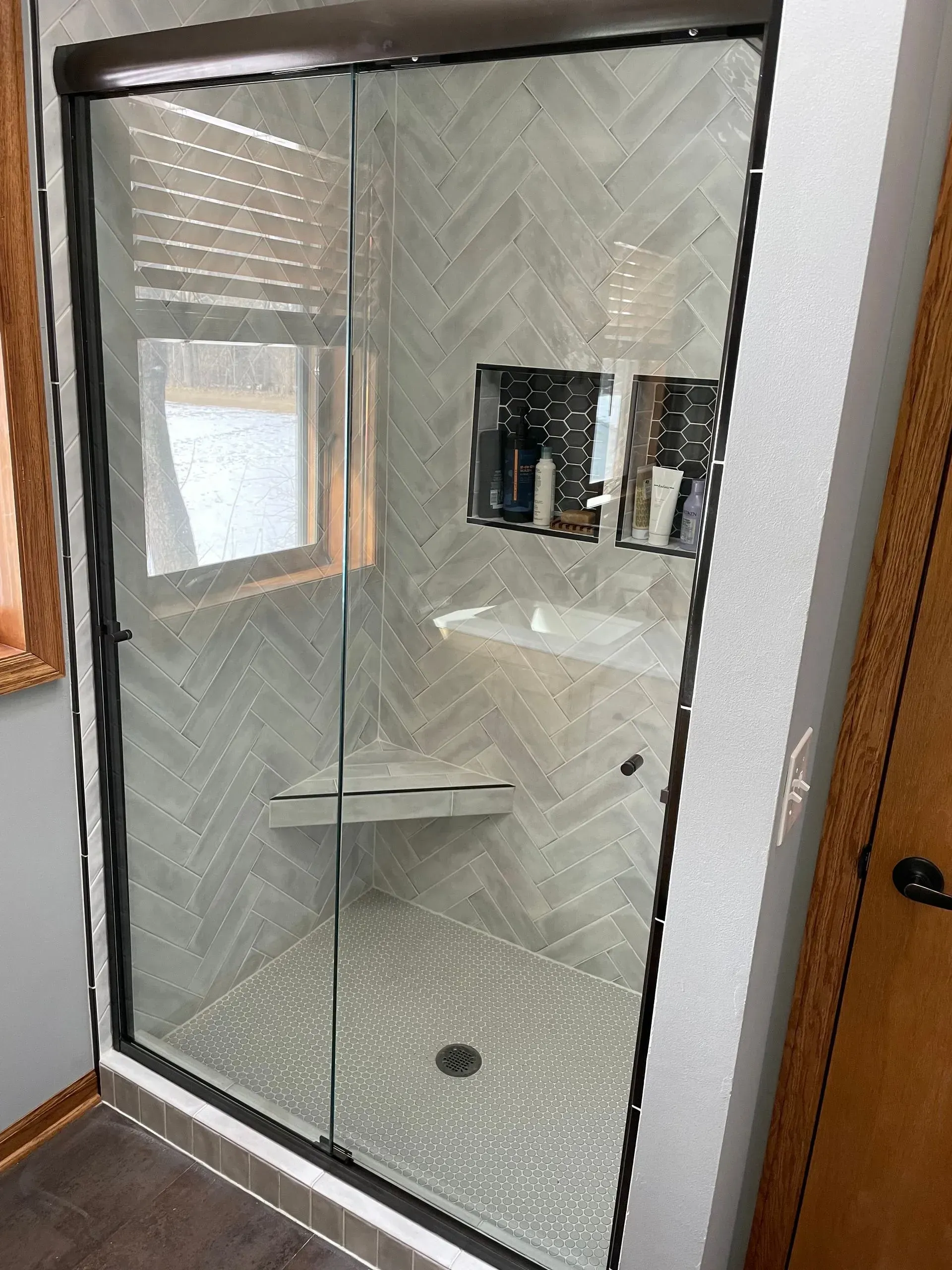 A bathroom with a sliding glass shower door and a sink.