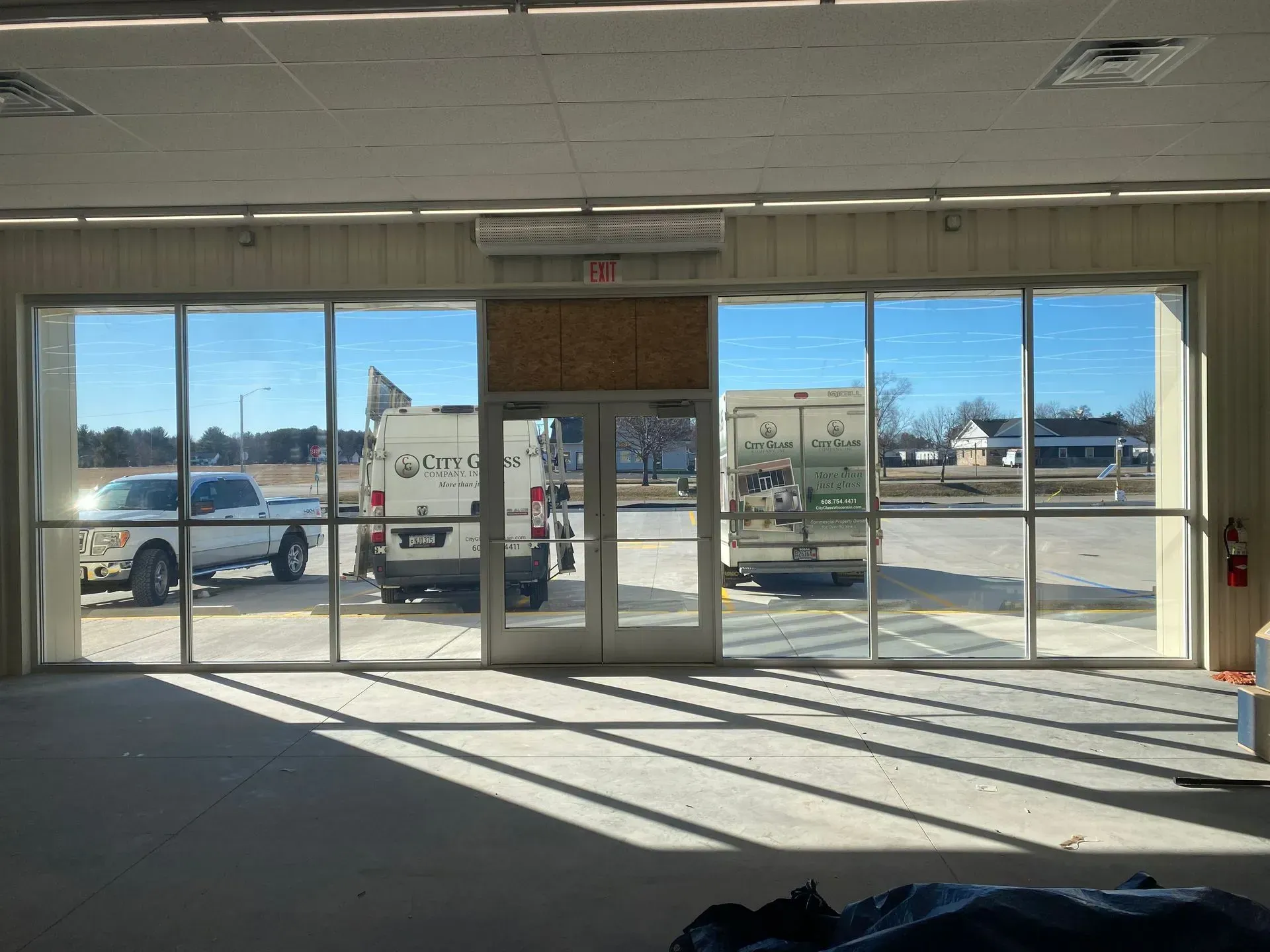 An empty room with a lot of windows and a truck parked in the background