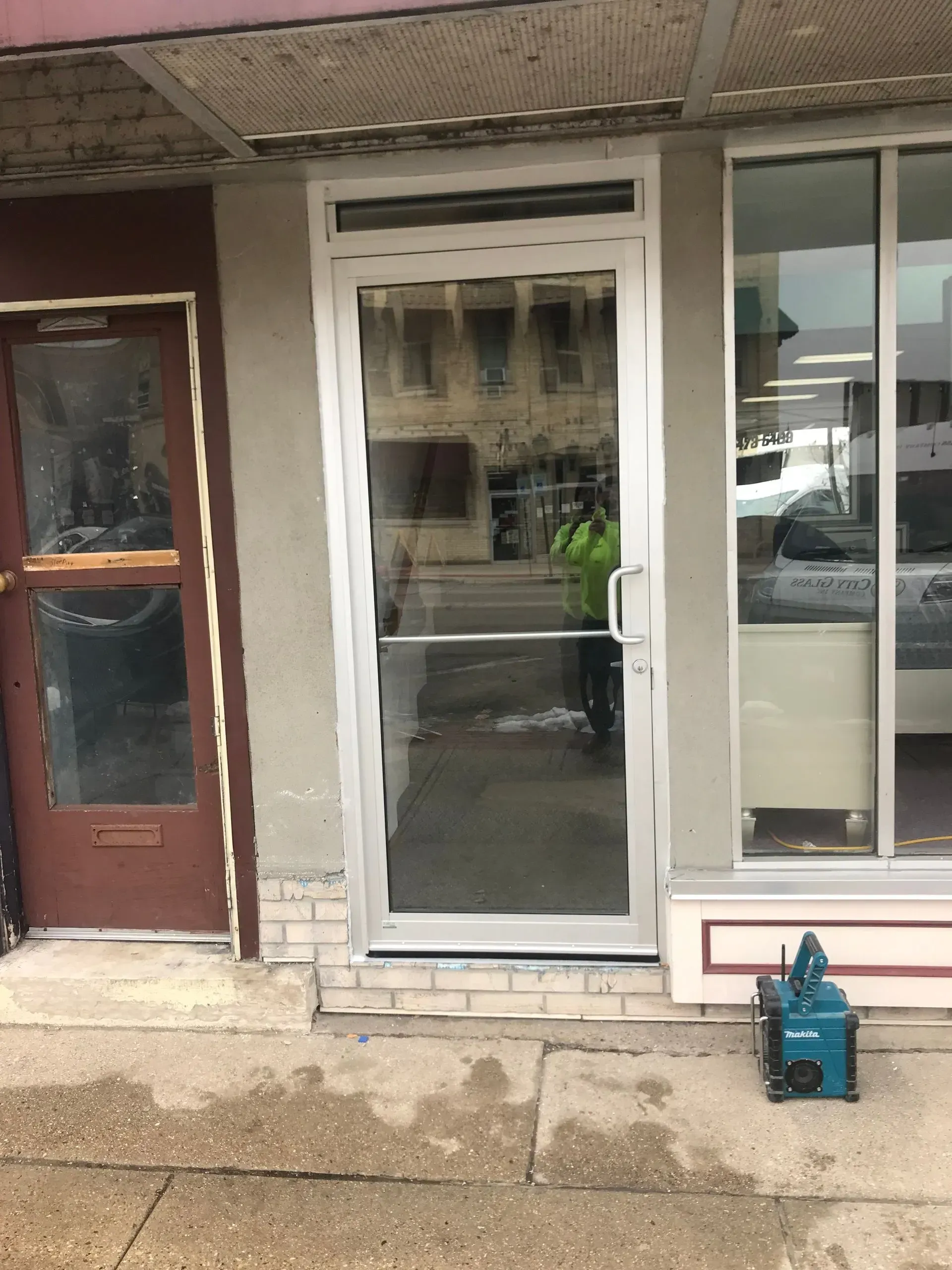 A store front with a white door and glass windows