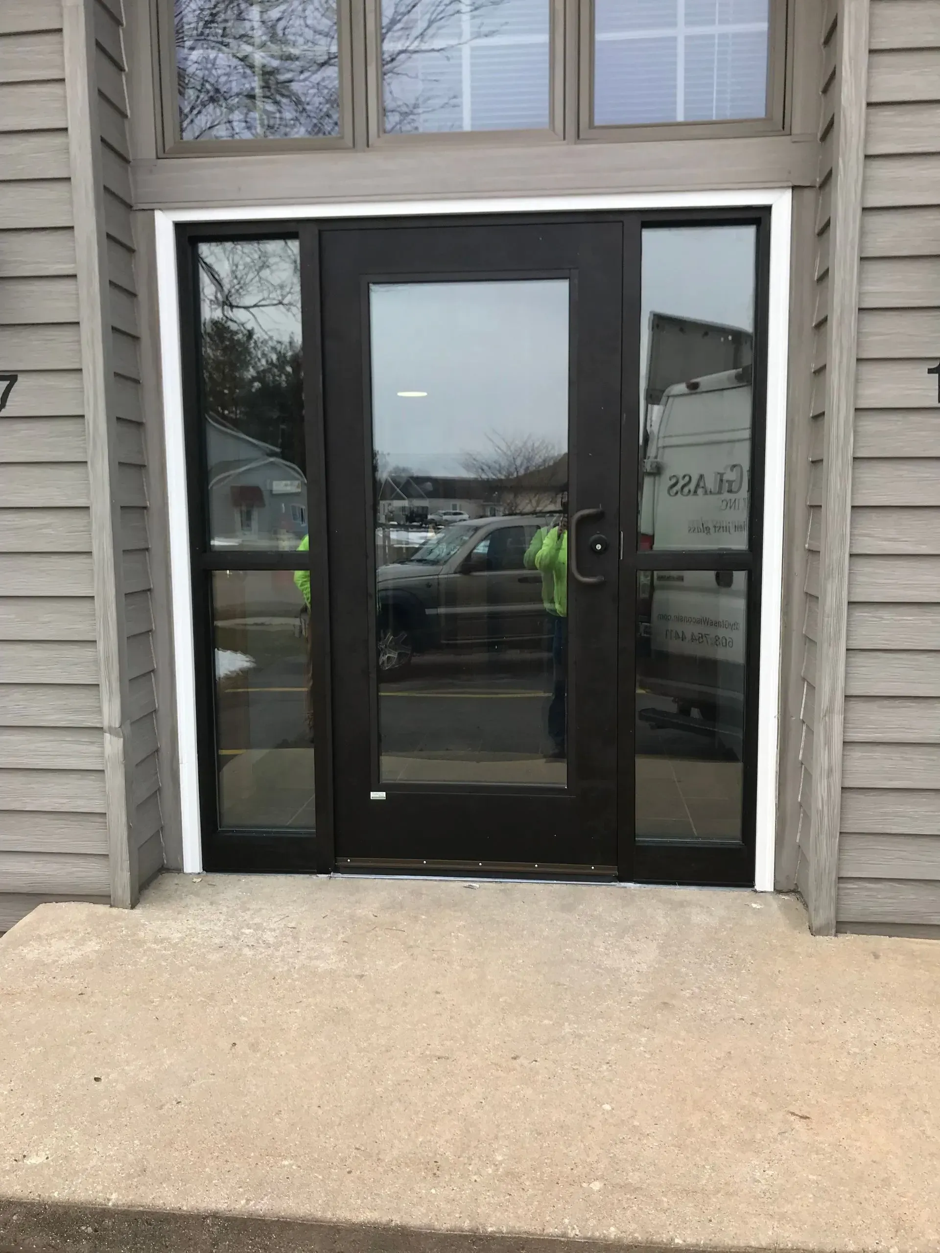 A black door with a white trim is sitting on the side of a building.