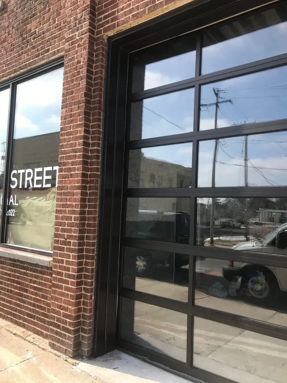 A brick building with a garage door and a sign that says street