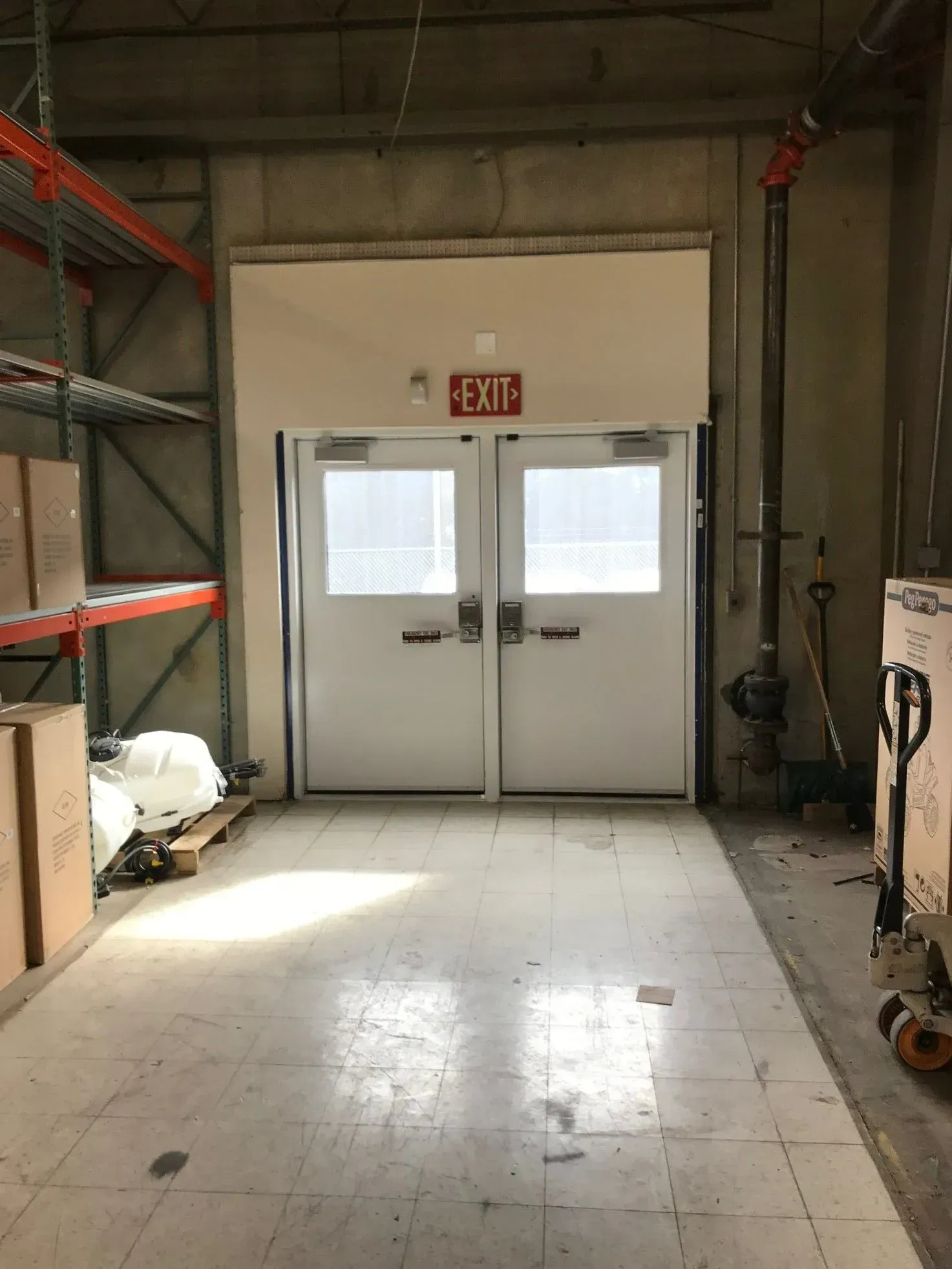 A warehouse with a red exit sign on the wall