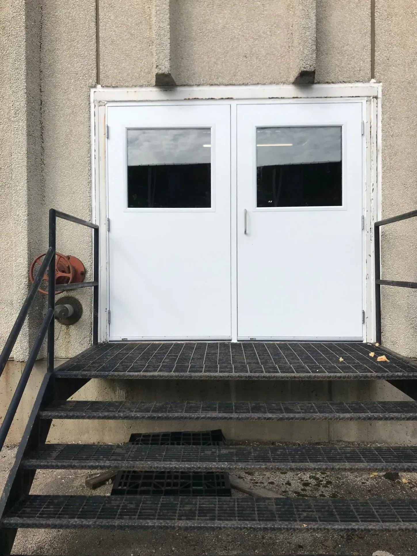 A pair of white doors with stairs leading to them.