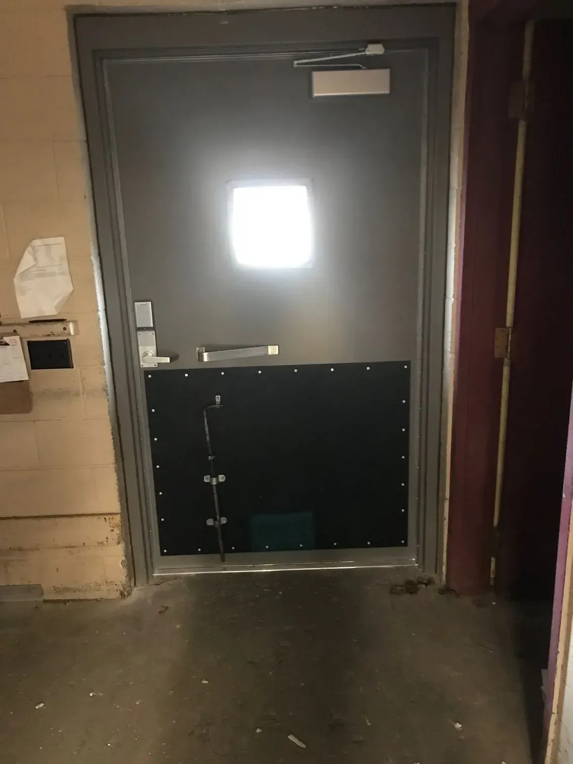 A door in a room with a light shining through it.