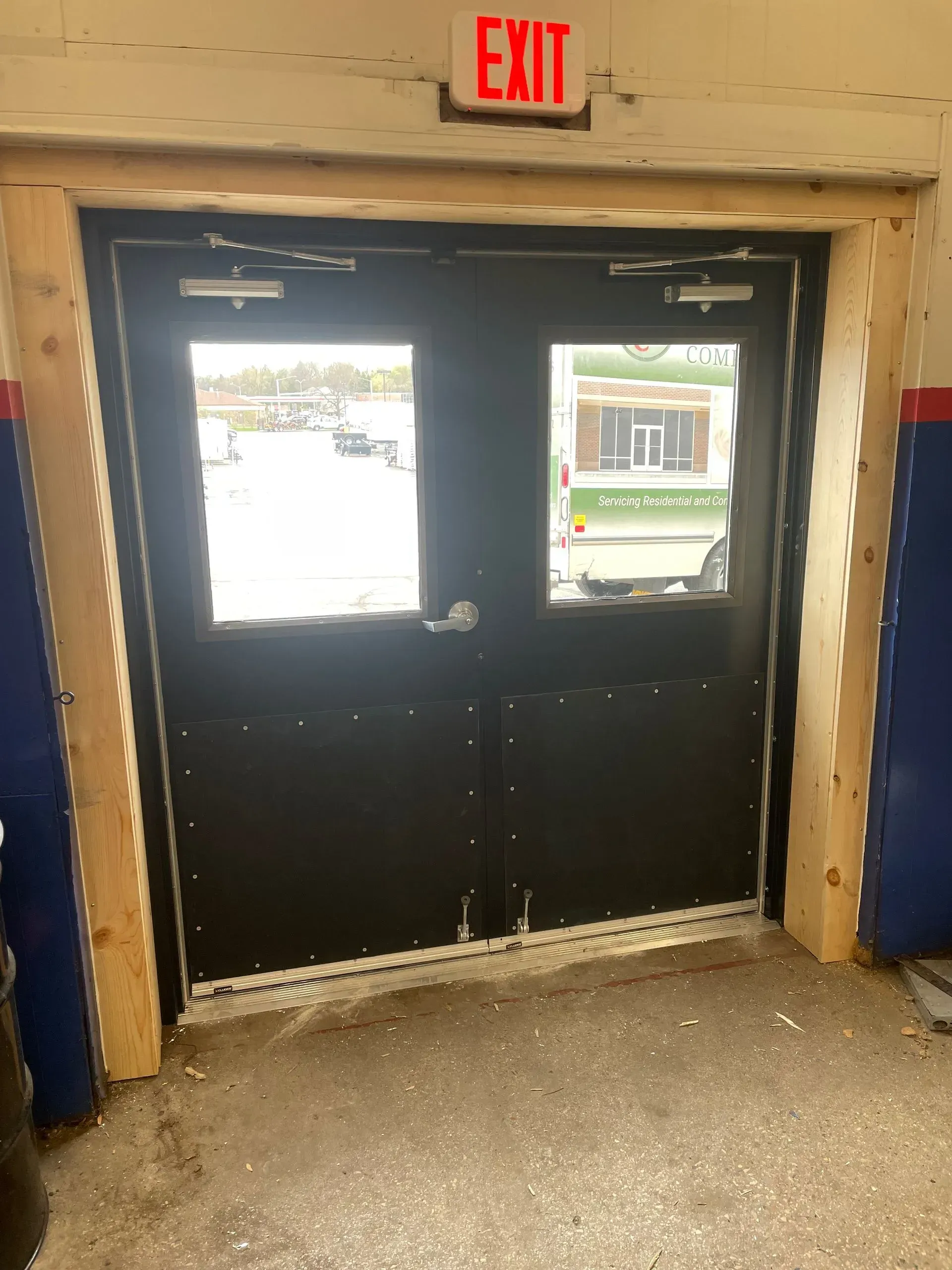 A black door with a red exit sign above it