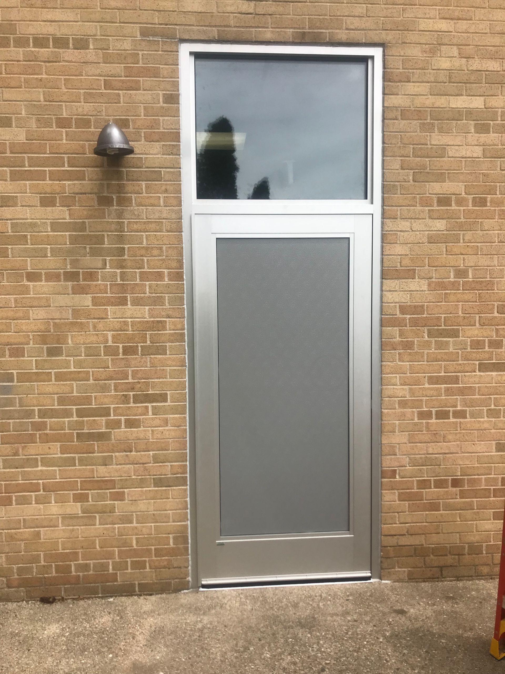 A brick building with a stainless steel door
