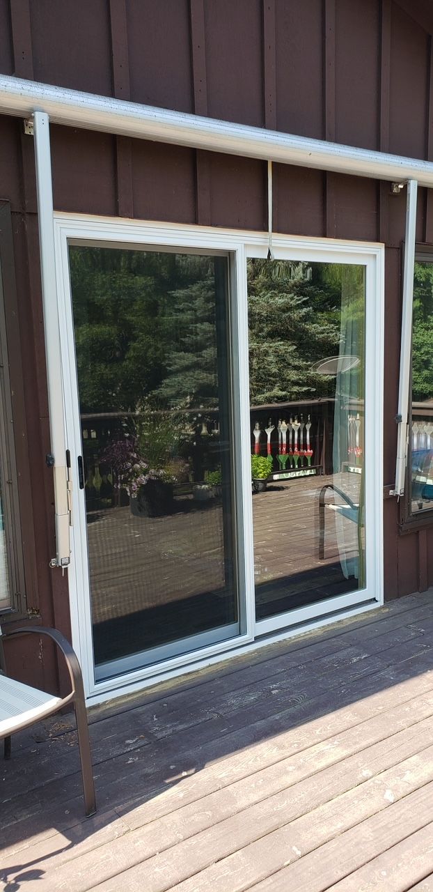 There is a sliding glass door on the side of a house.
