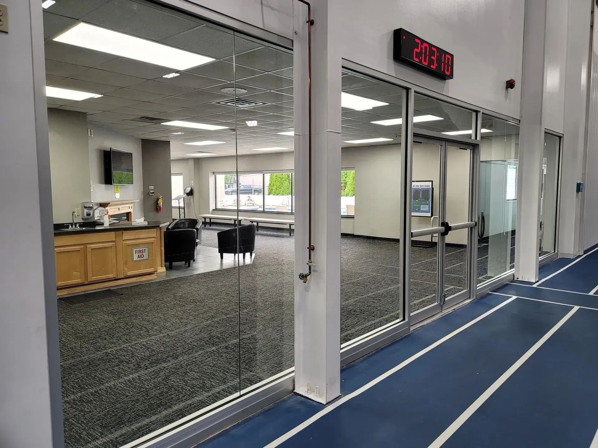 A large room with a blue track and a digital clock on the wall.