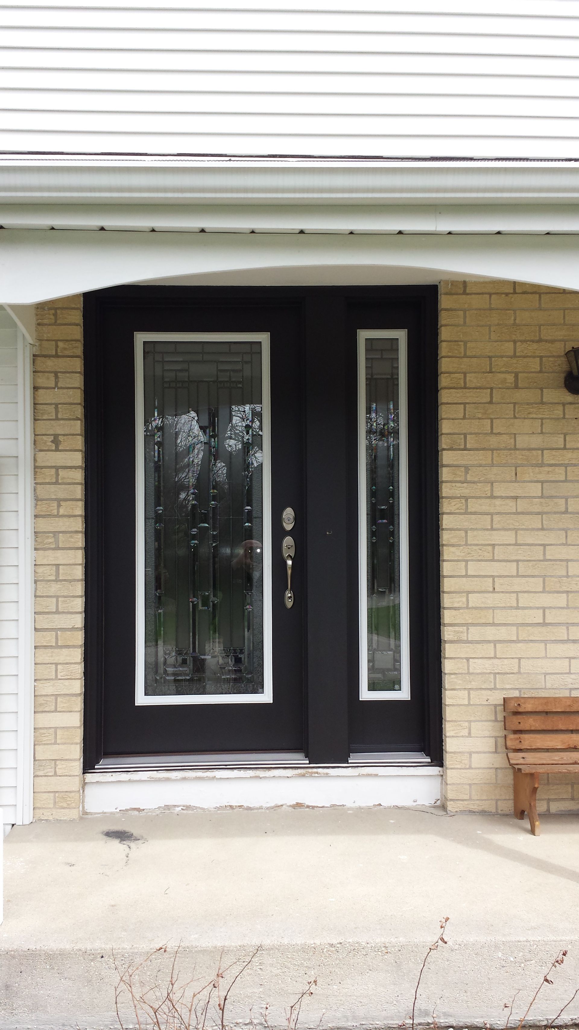 The front door of a brick house with a black door