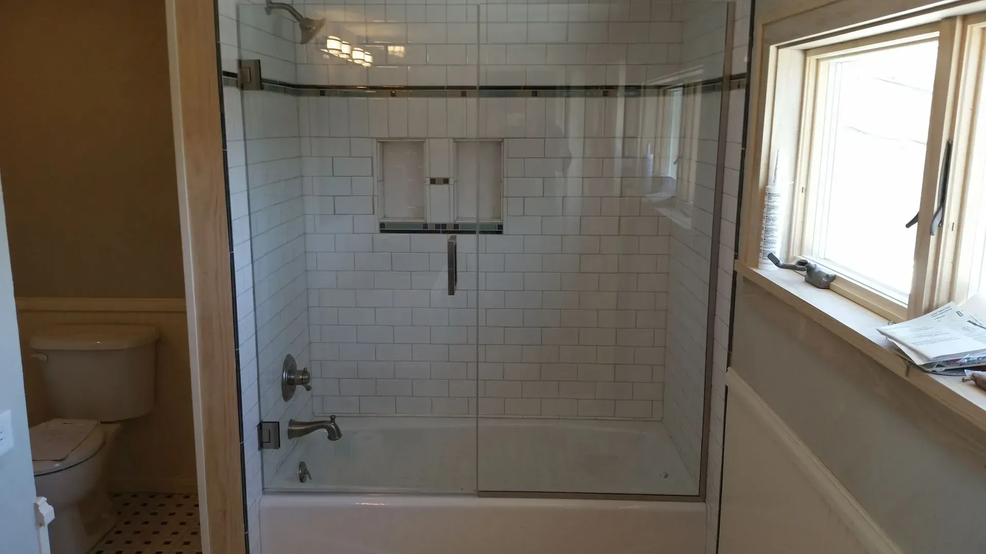 A bathroom with a tub and a shower with a glass door
