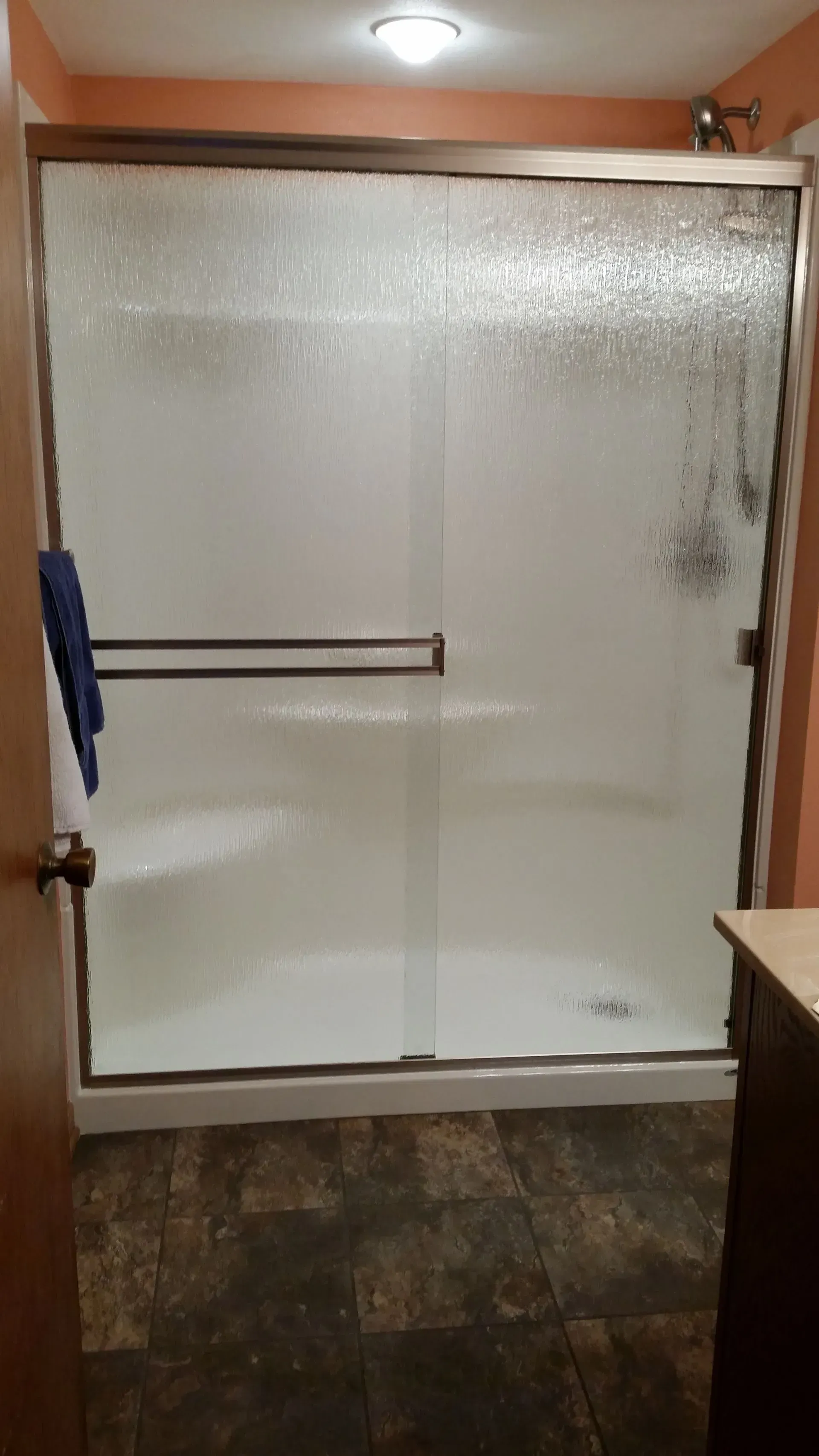 A bathroom with a sliding glass shower door and a sink.