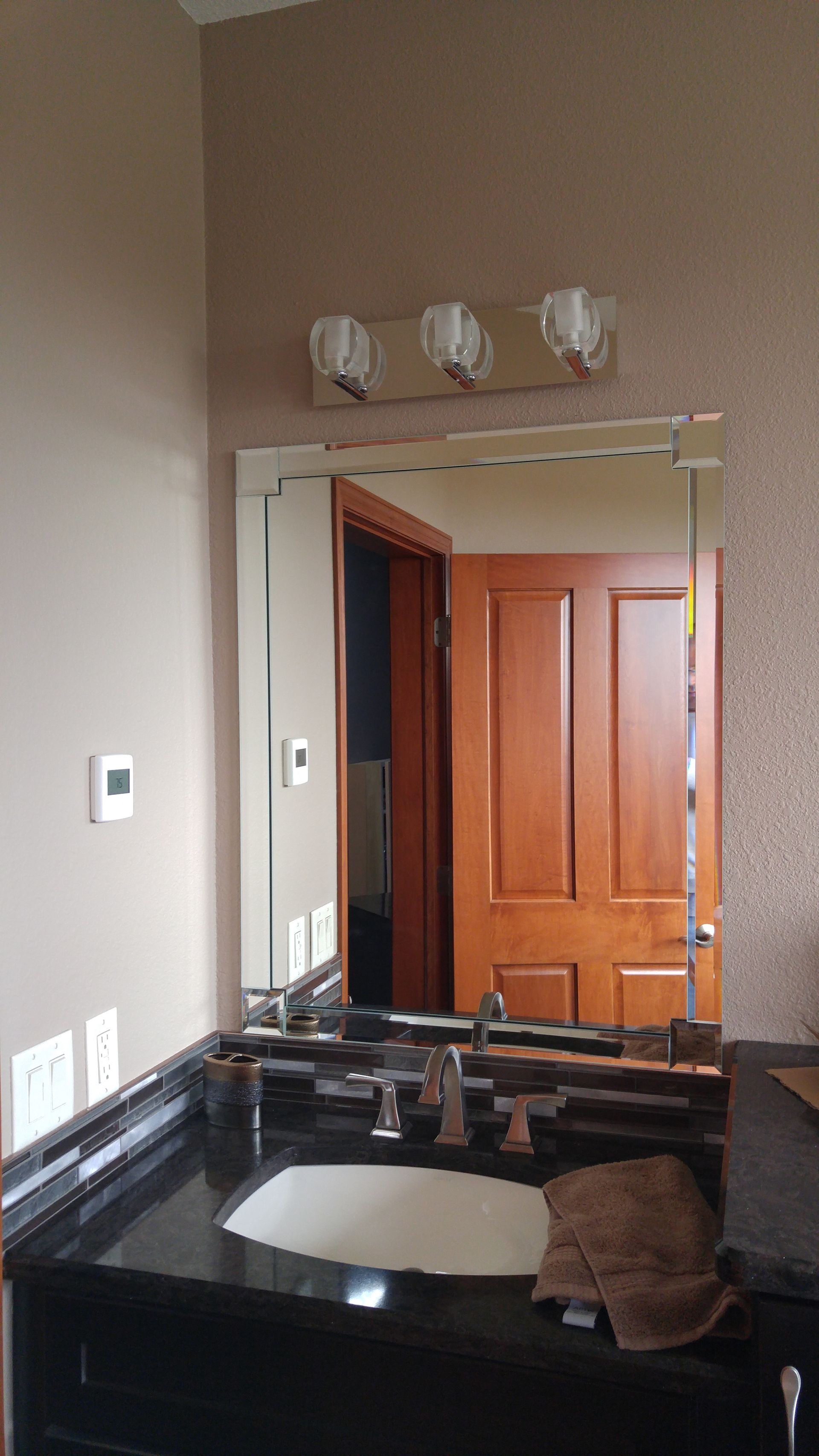 A bathroom with a sink , mirror and light fixture.