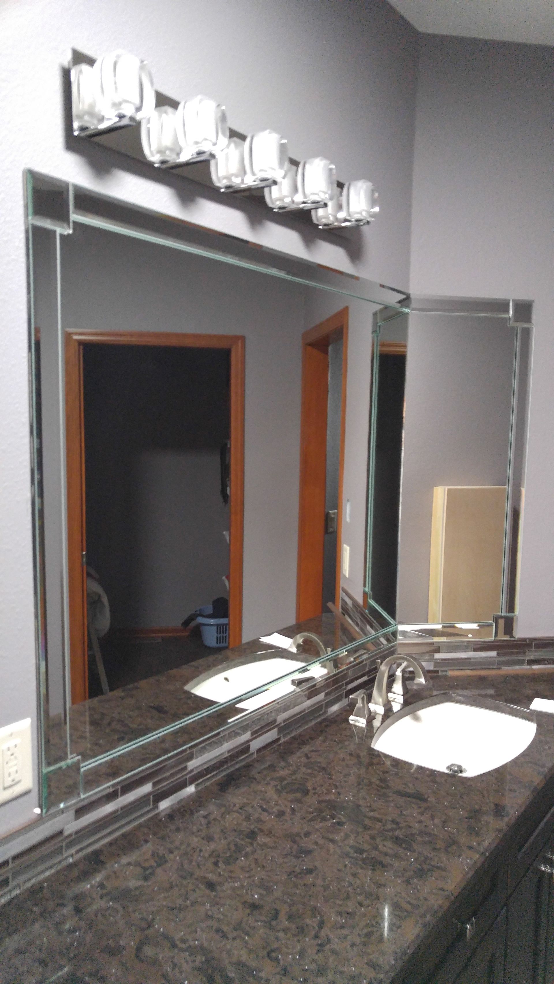 A bathroom with a large mirror and two sinks.