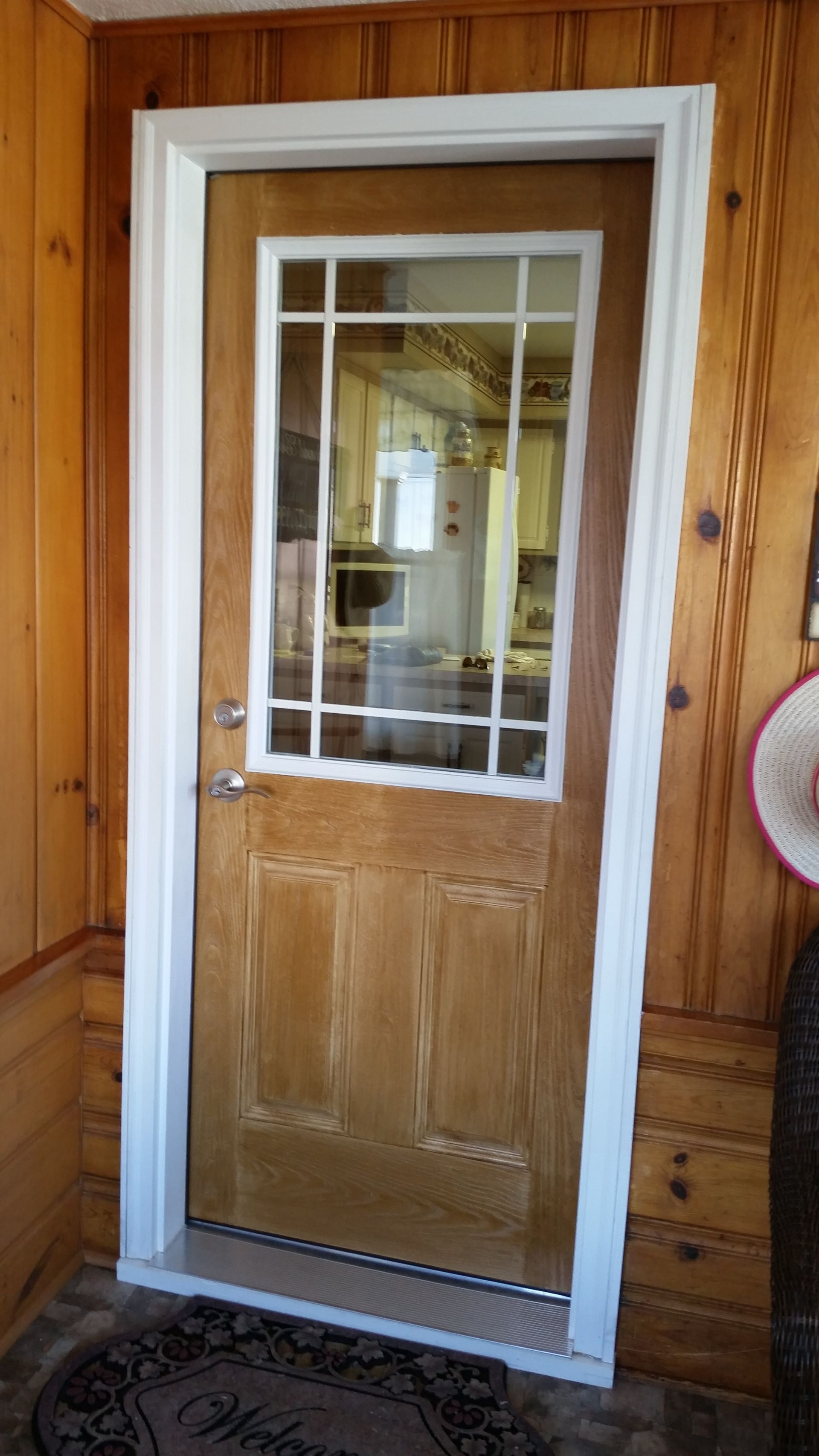 A wooden door with a glass window in a wooden house.